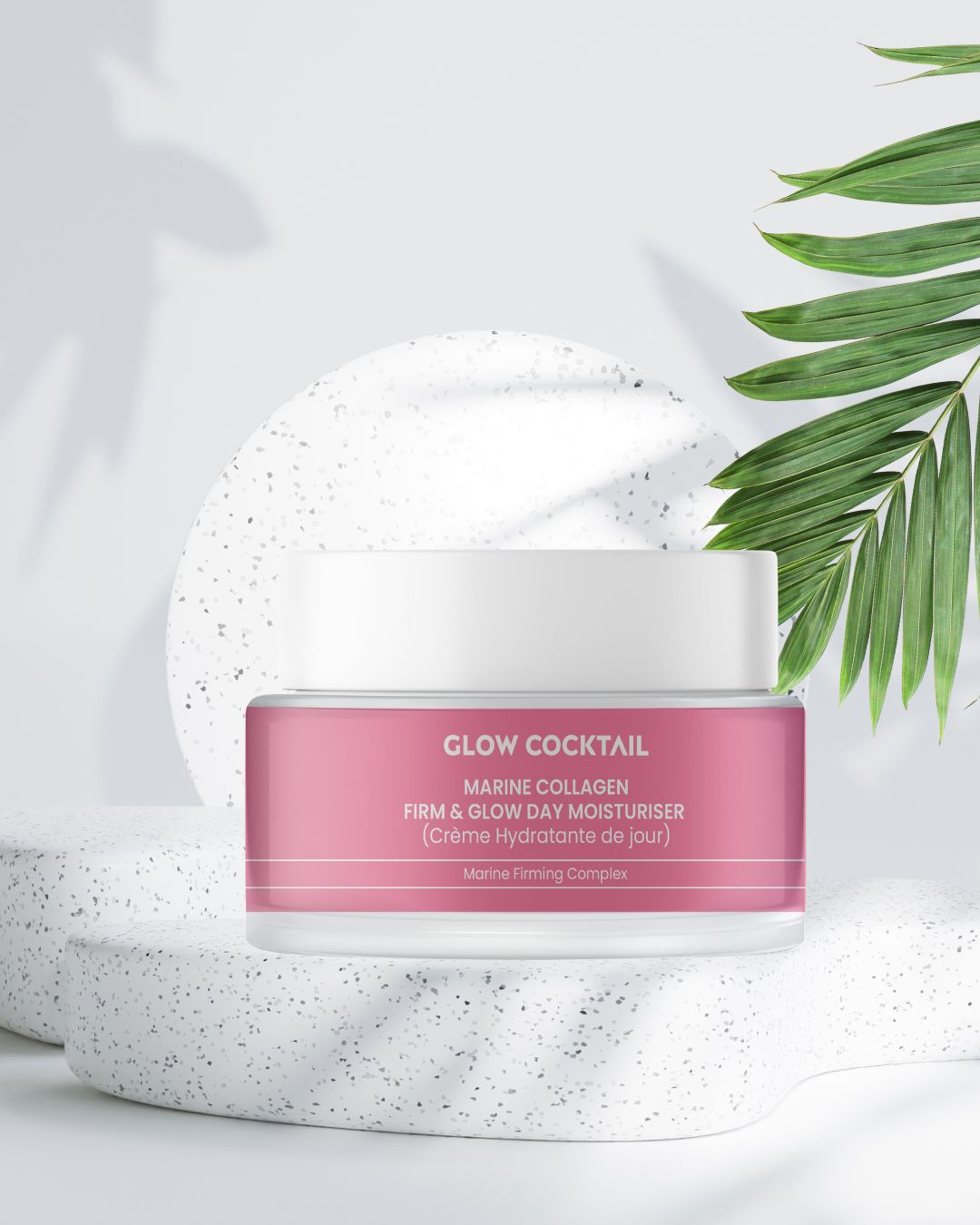 Vaso di crema rosa con coperchio bianco su piedistallo. Scritta: Marine Collagen Firm & Glow Day Moisturiser. Marchio: Glow Cocktail.