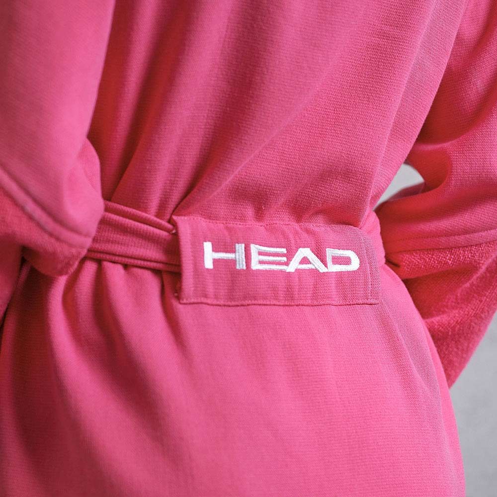 Primo piano della schiena di un accappatoio rosa. La scritta "HEAD" è bianca sulla cintura.
