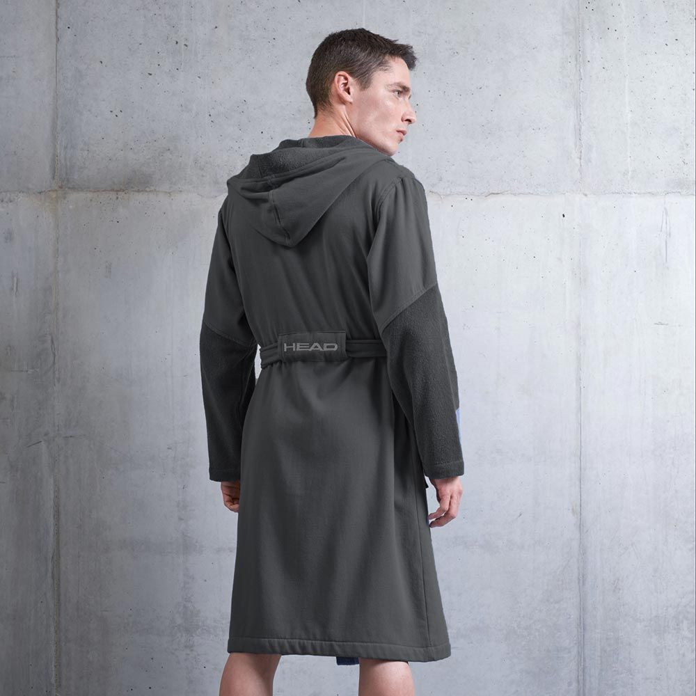Accappatoio grigio con cappuccio e cintura. Vista posteriore di un uomo. Scritta HEAD sulla cintura. Sfondo grigio.