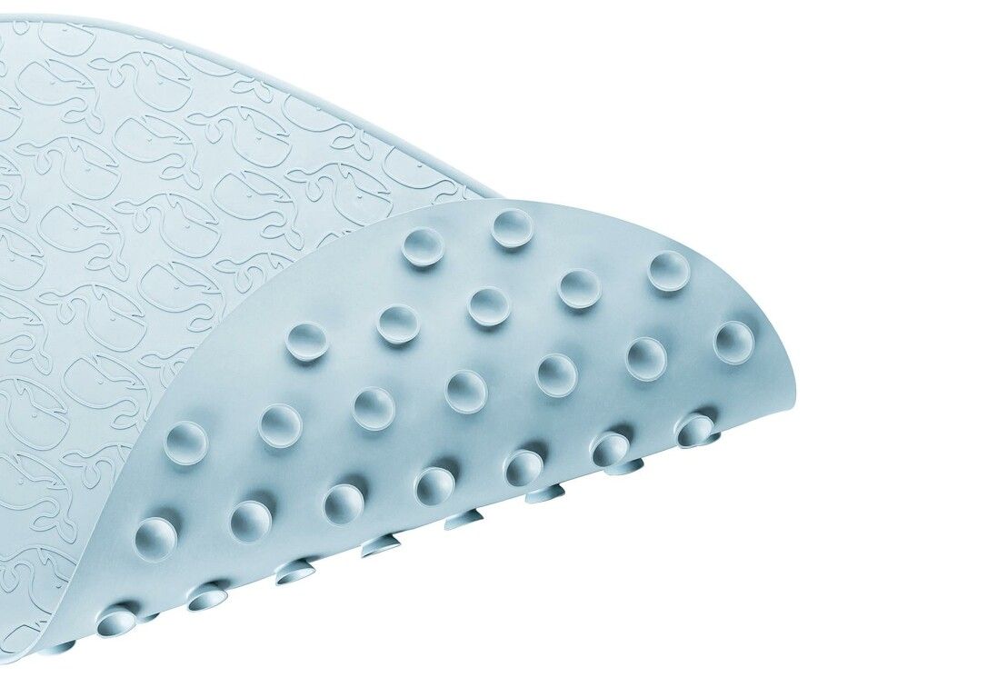 Tappetino da bagno azzurro con motivi di balene. Il lato inferiore ha ventose. La superficie è strutturata.