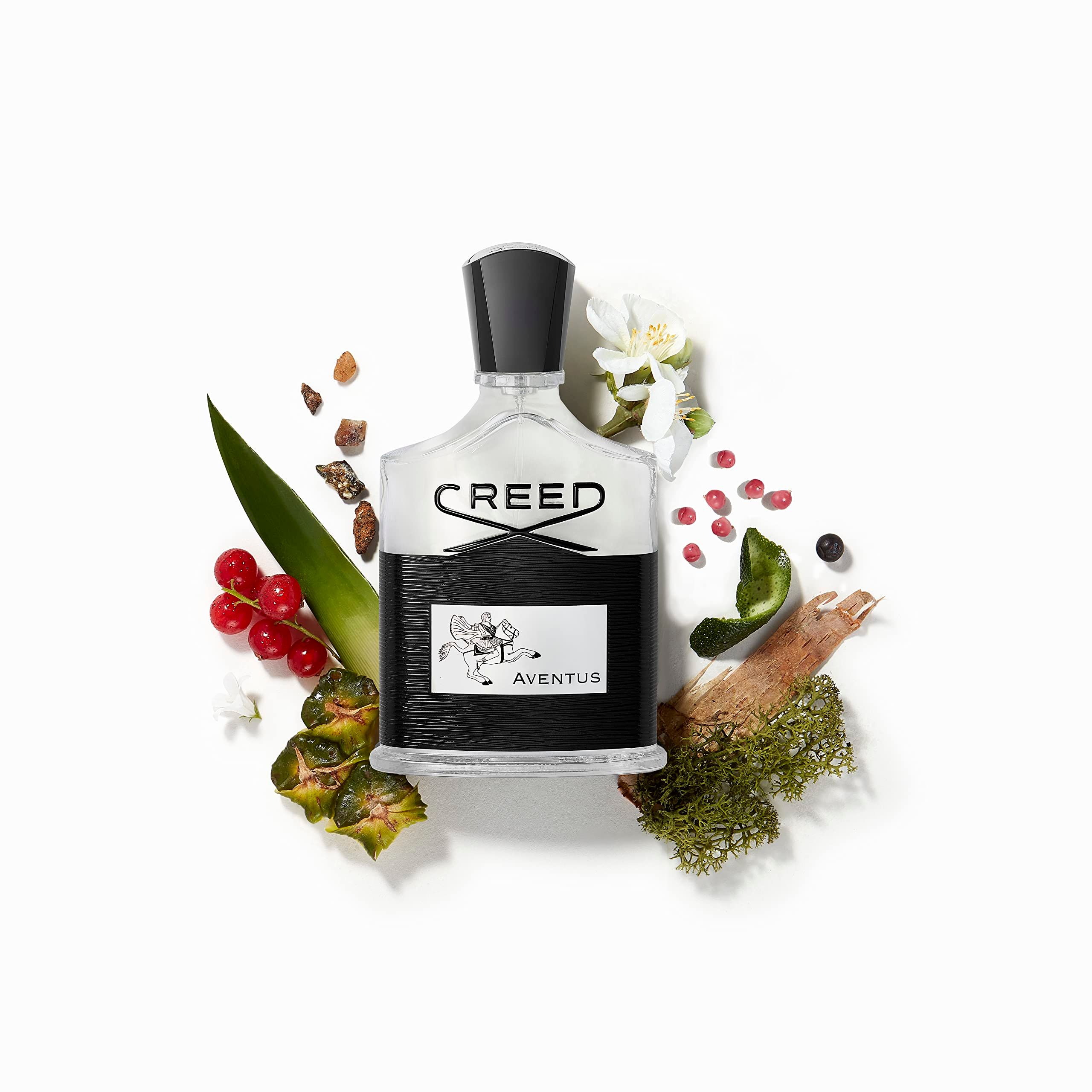 Flacone di profumo con etichetta nera e scritta bianca. Circondato da foglie, bacche e fiori.