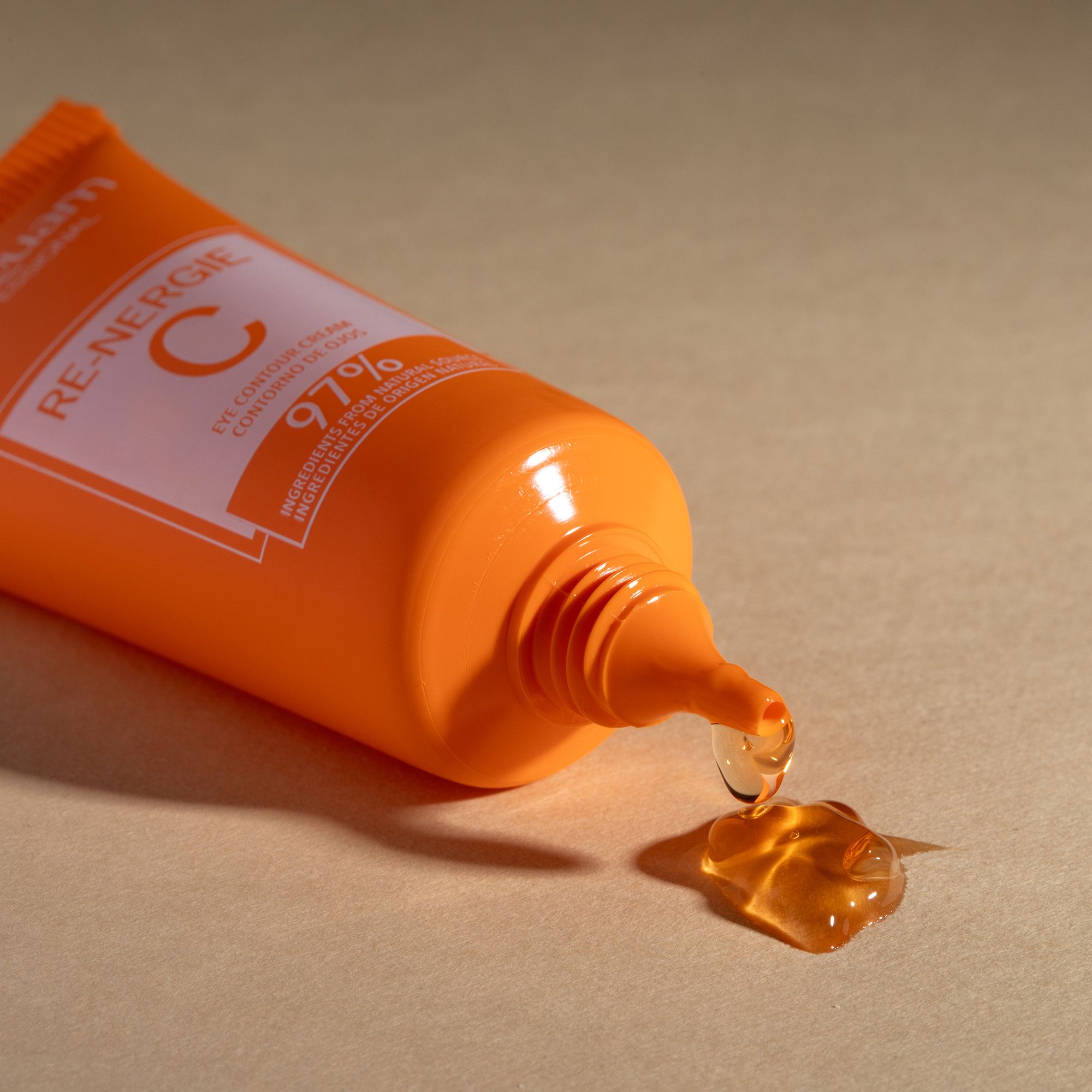 Postquam Re-Nergie C crema contorno occhi. Tubo arancione, prodotto che gocciola. Testo: Eye Contour Cream, 97% ingredienti naturali.