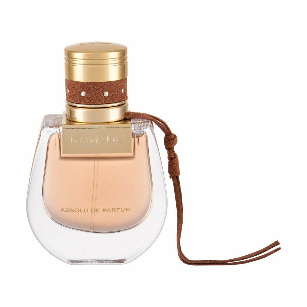 Flacone di profumo con tappo dorato, cinturino in pelle marrone. Scritta 'Nomade Absolu de Parfum'. Flacone trasparente.