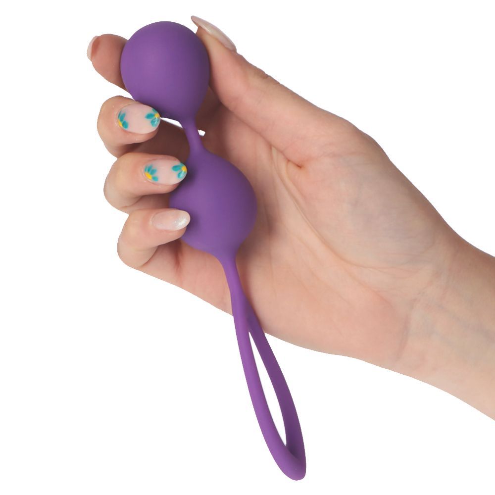 Palle di Kegel viola tenute in mano. Le palle sono collegate da un gambo, con un anello all'estremità.