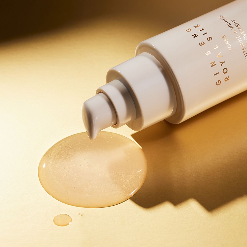 Flacone beige con dosatore, liquido su sfondo dorato. Testo: Ginseng Royal Silk.