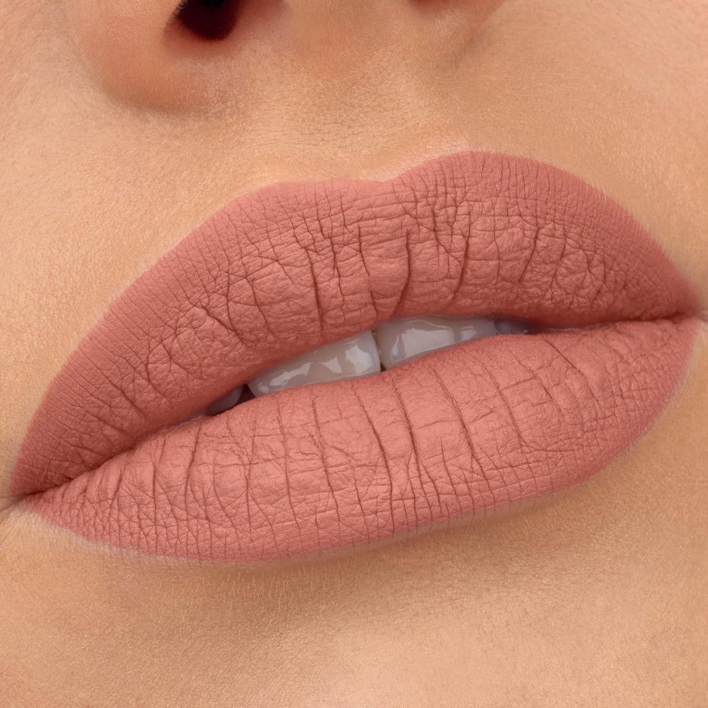 Primo piano di labbra coperte da rossetto liquido opaco 8h Essence. Colore rosa opaco. Contorni labbra definiti.