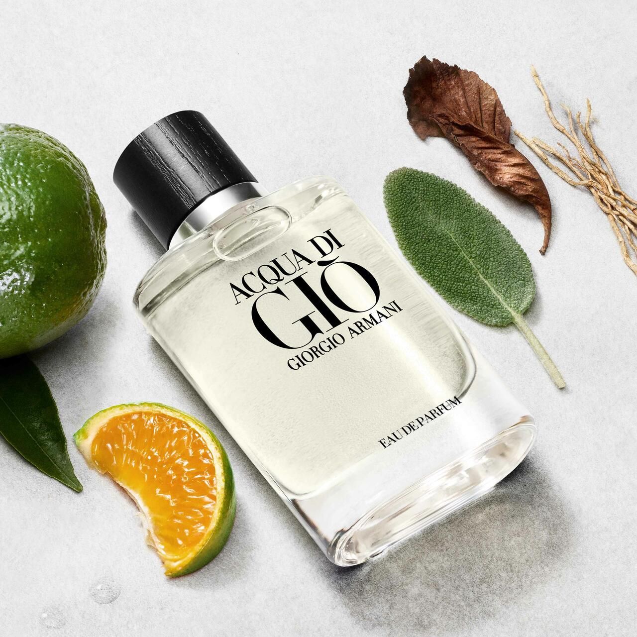 Flacone ACQUA DI GIÒ, circondato da lime, arancia, foglie e ramoscelli. Scritta: ACQUA DI GIÒ, EAU DE PARFUM, GIORGIO ARMANI.