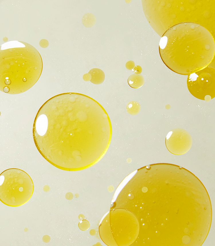 Goccioline d'olio gialle di varie dimensioni su sfondo chiaro.