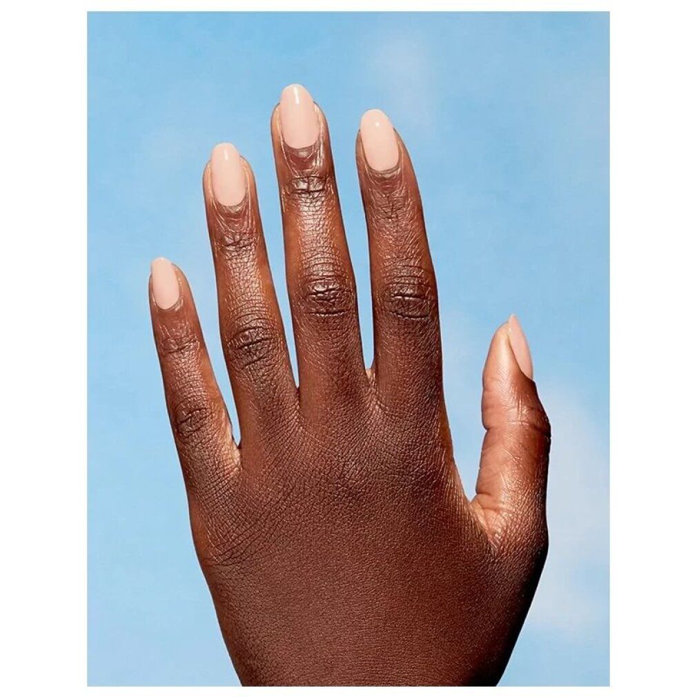 Mano con unghie smaltate rosa chiaro su sfondo blu.
