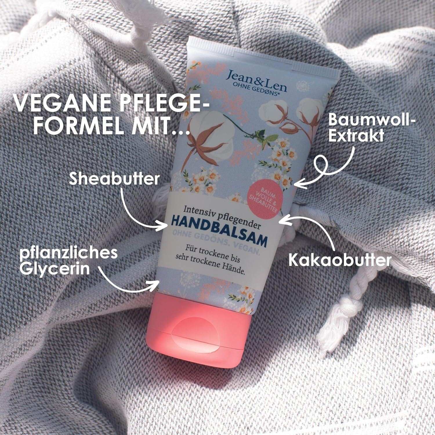 Tubo di balsamo per le mani con motivo cotone e burro di karité. Testo: HANDBALSAM, Vegan. Ingredienti: Burro di karité, glicerina, burro di cacao, estratto di cotone.