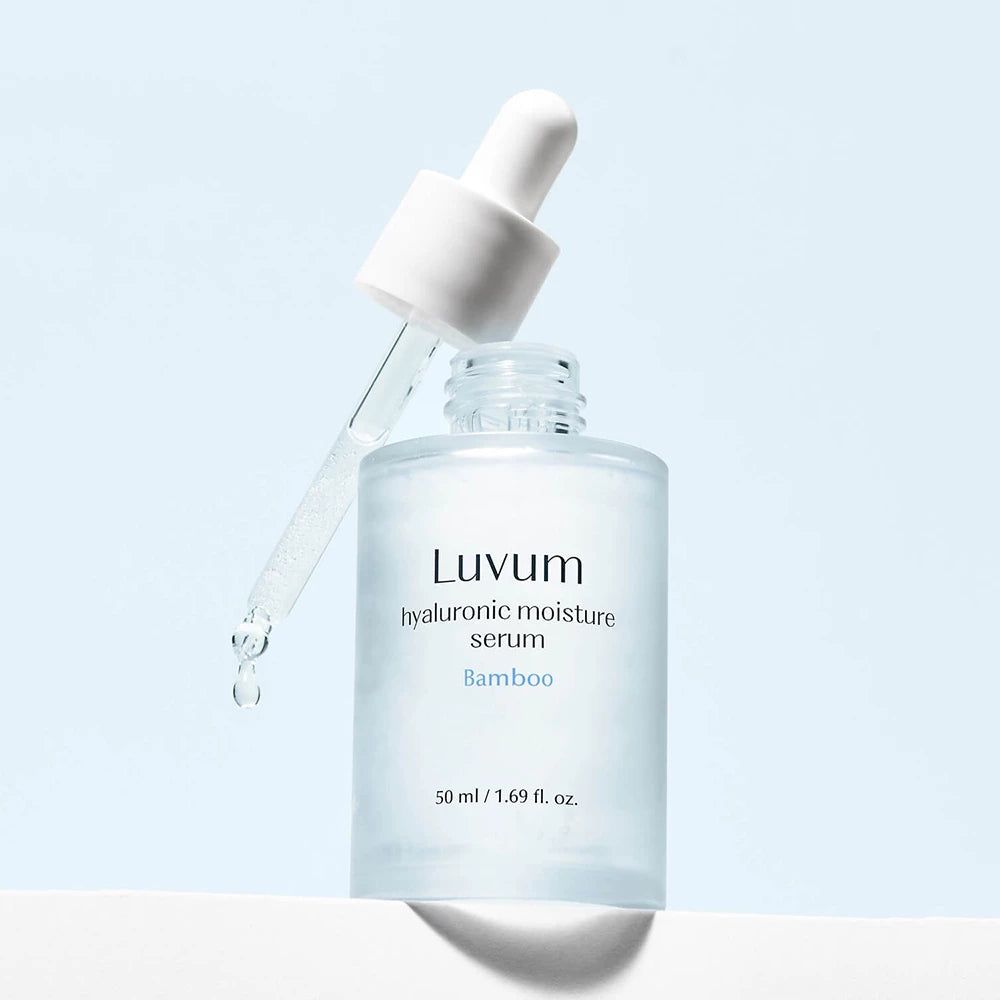 Flacone di vetro con pipetta. Scritta: Luvum, siero idratante all'acido ialuronico, bambù. Gocce che cadono dalla pipetta.