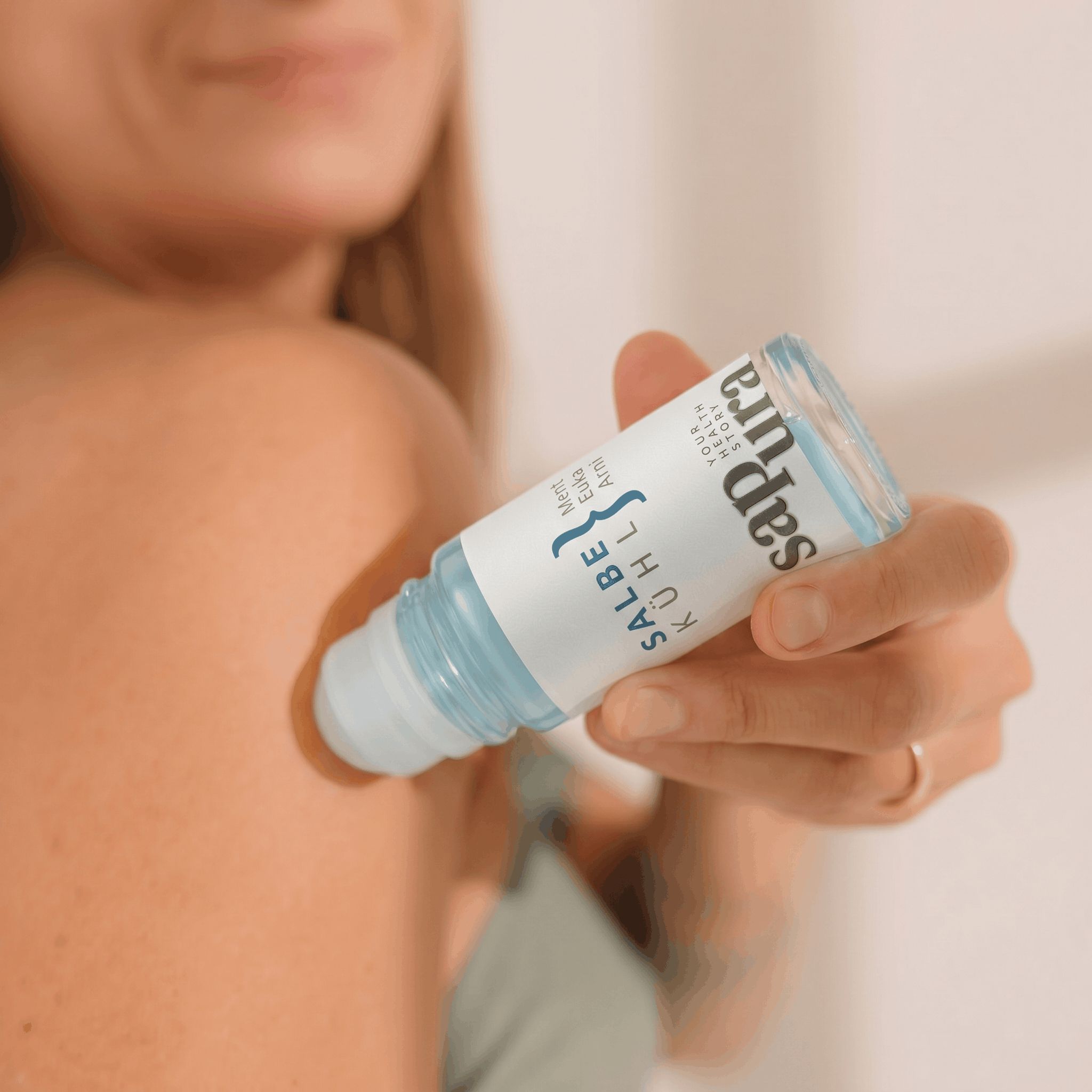 Mano applica il gel rinfrescante roll-on sapura health® sulla spalla.