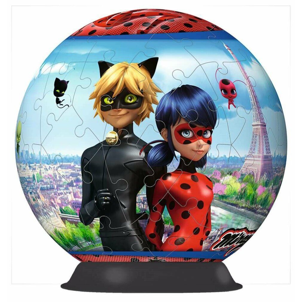 Puzzleball 3D con motivo coccinella e gatto nero. Forma sferica, su supporto. Torre Eiffel sullo sfondo.