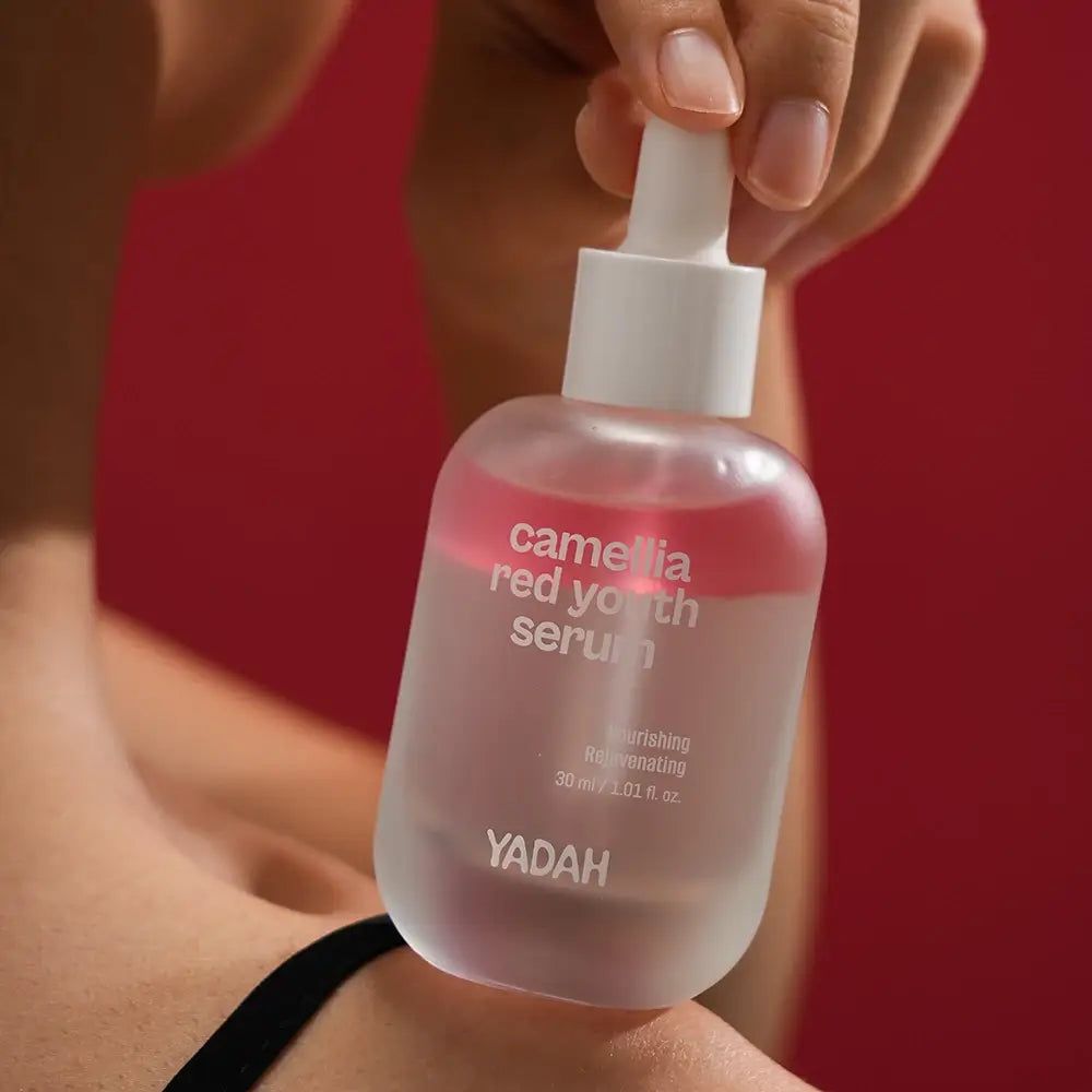 Flacone di siero con tappo e pipetta bianchi. Scritta: Camellia Red Youth Serum. Marchio YADAH.