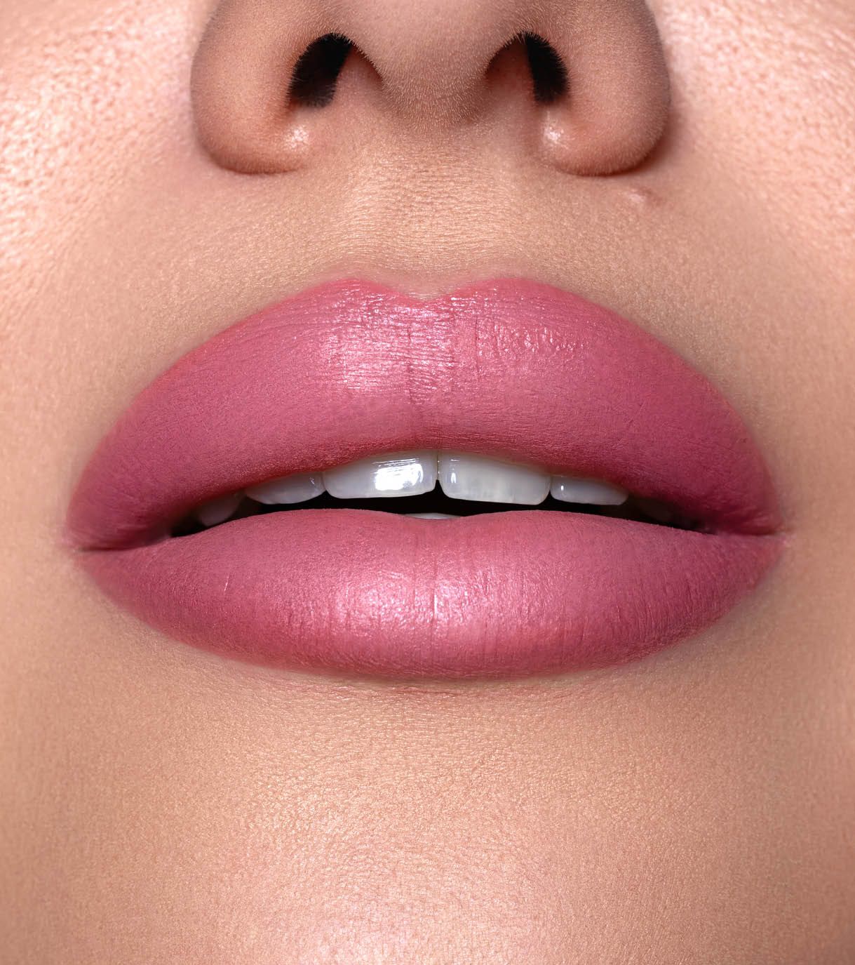 Primo piano di labbra con rossetto opaco color rosa.