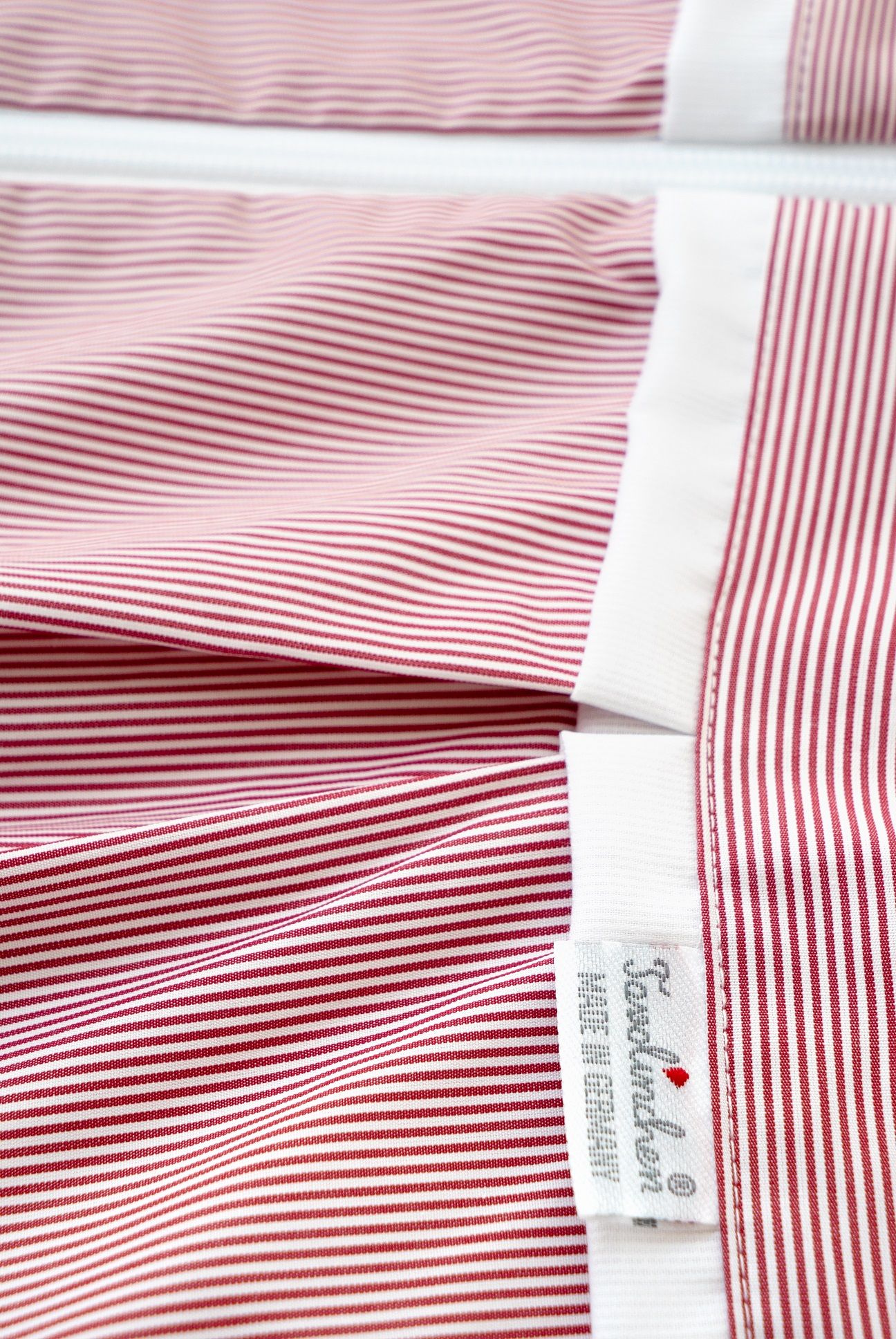 Vista dettagliata del sacco nanna. Strisce rosse e bianche, orlo bianco. Marchio Tavolinchen, Made in Germany.