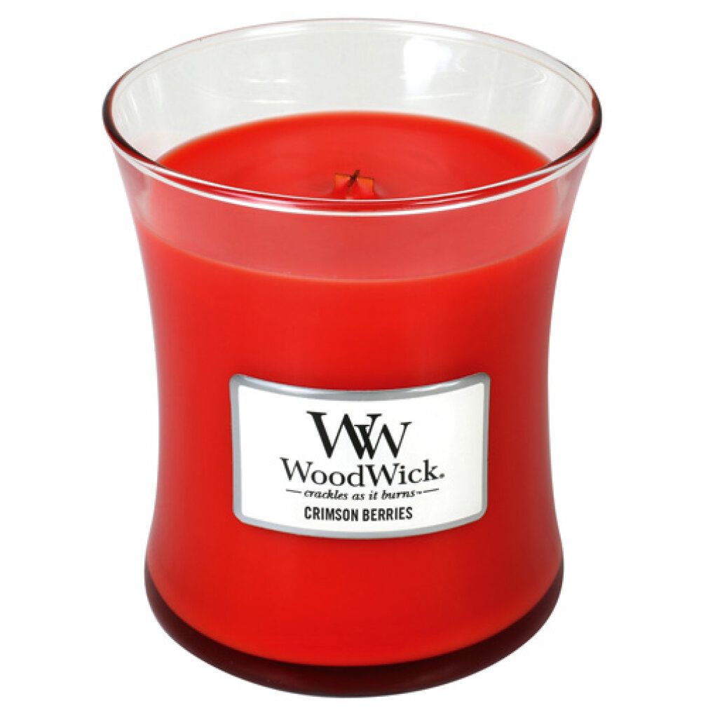 Candela rossa a forma di clessidra con bordo in vetro. Etichetta bianca con logo e 'Crimson Berries'.