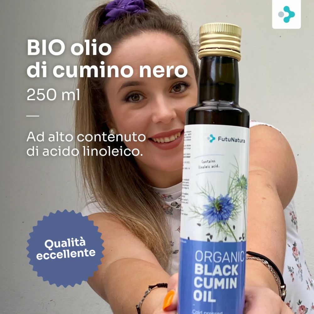 Donna tiene una bottiglia di olio di cumino nero. BIO Schwarzkümmelöl, 250 ml. Alto contenuto di acido linoleico. Qualità eccellente.