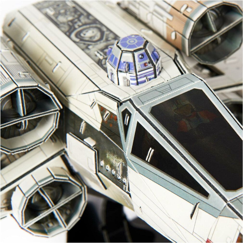 Primo piano dell'abitacolo del modello X-Wing. Dettagli blu e bianchi. Figura di R2-D2 visibile.