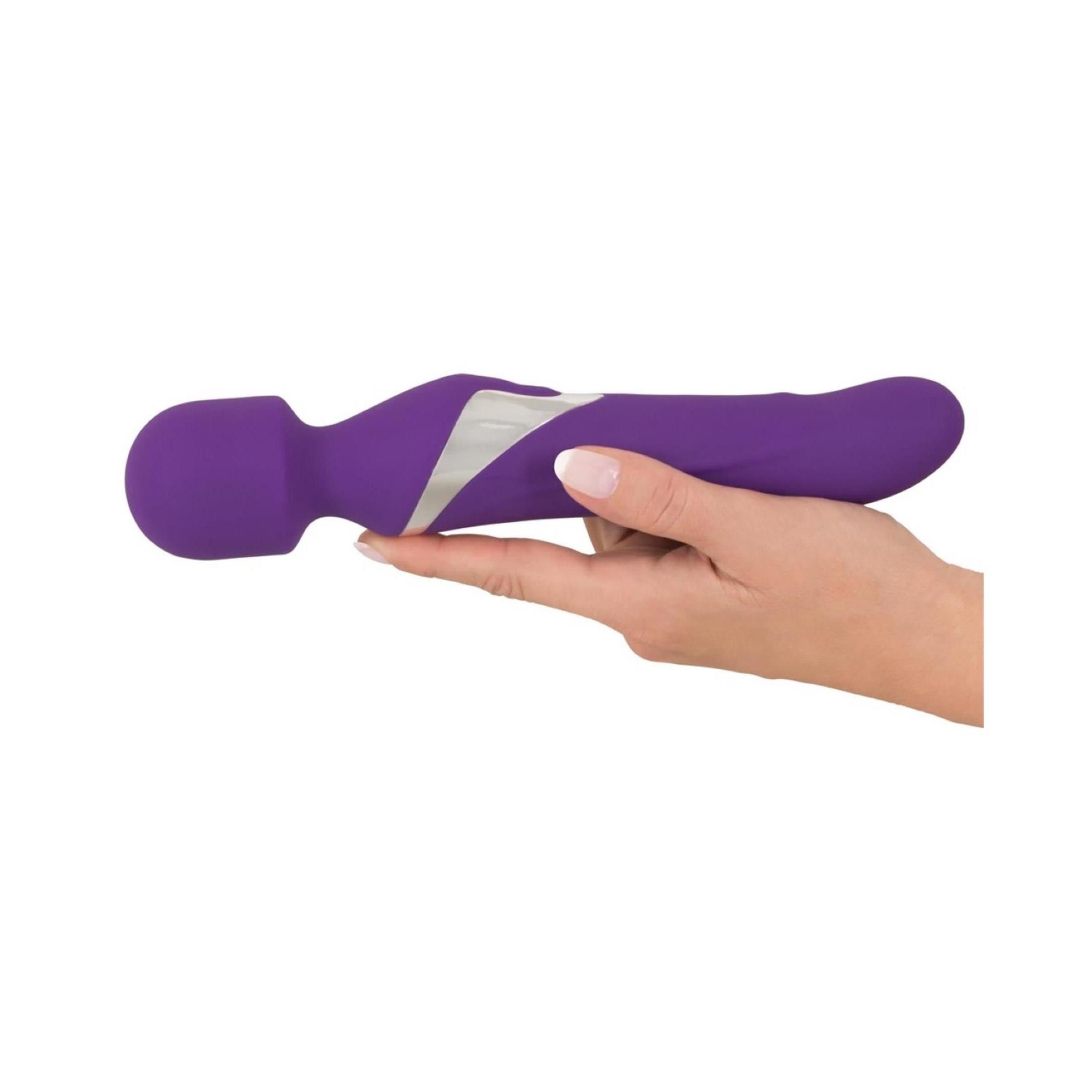 Massaggiatore viola tenuto in mano. Dettaglio argento. Testa arrotondata e forma ergonomica.