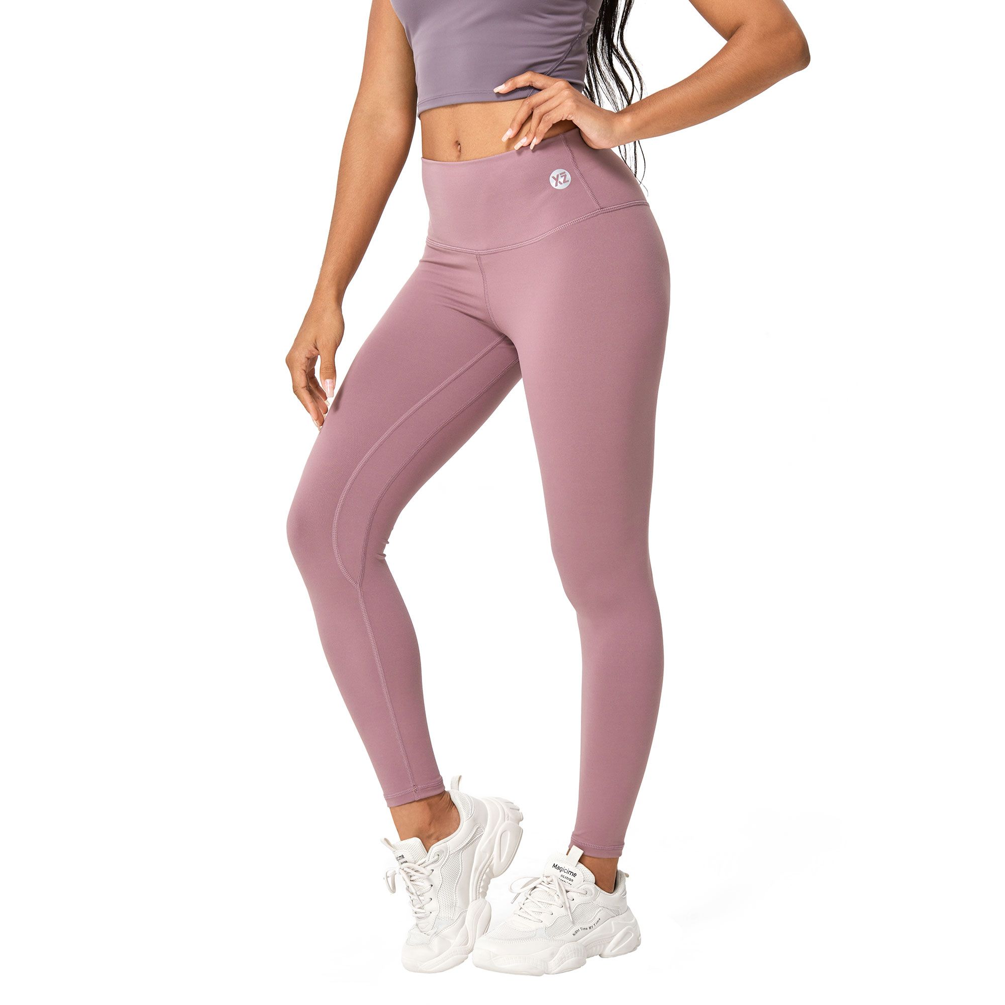 Leggings da allenamento viola a vita alta con cuciture discrete. Piccolo logo sul fianco sinistro.
