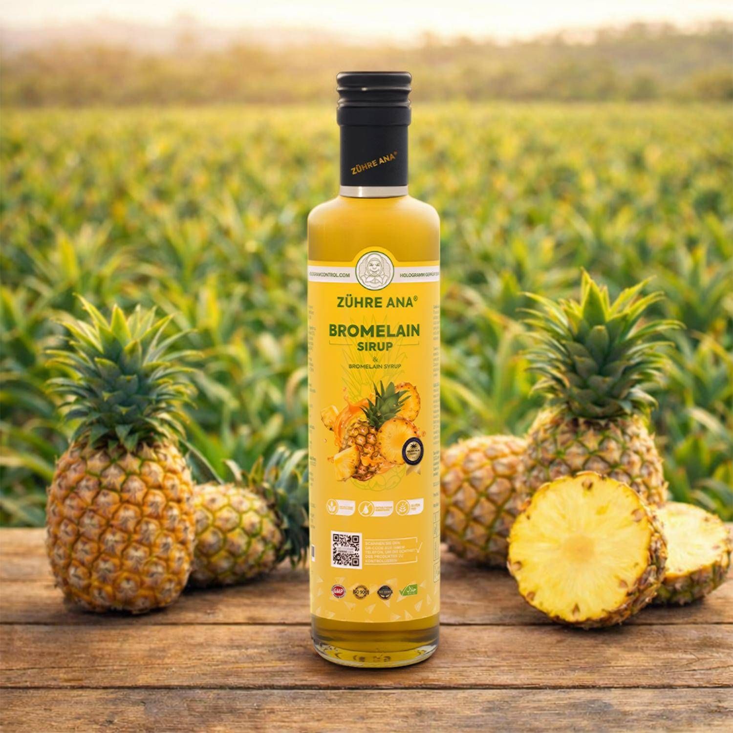 Bottiglia di sciroppo di bromelina Zühre Ana su tavolo di legno con ananas sullo sfondo.