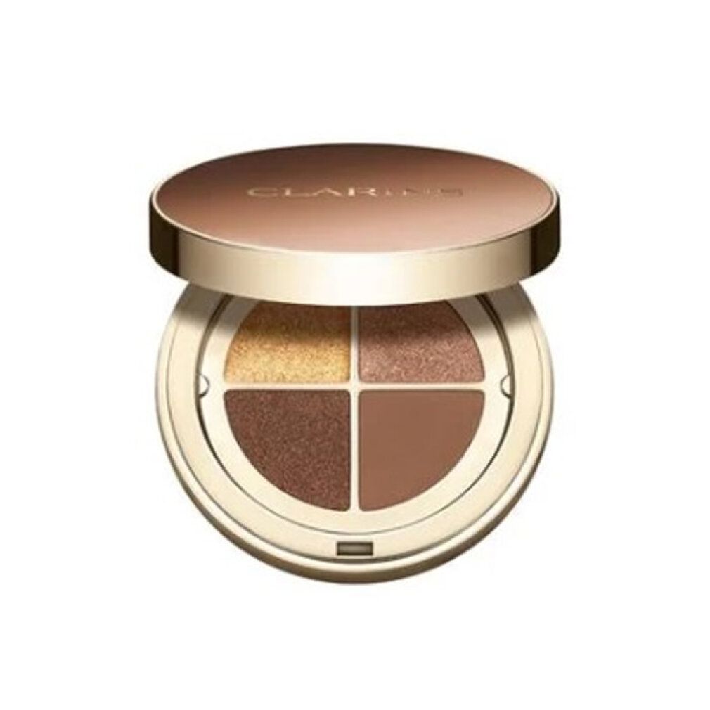 Palette ombretti rotonda, quattro colori. Coperchio dorato con scritta Clarins. Tonalità: oro, marrone, marrone scuro, marrone chiaro.