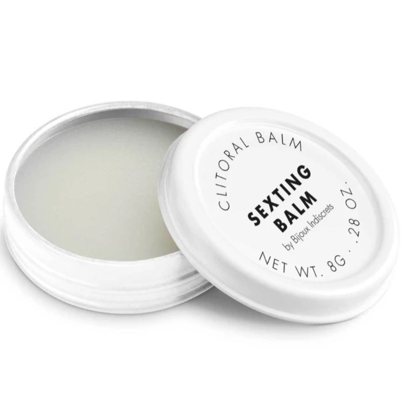 Un barattolo bianco aperto con Bijoux Indiscrets Sexting Balm. Il coperchio è accanto.