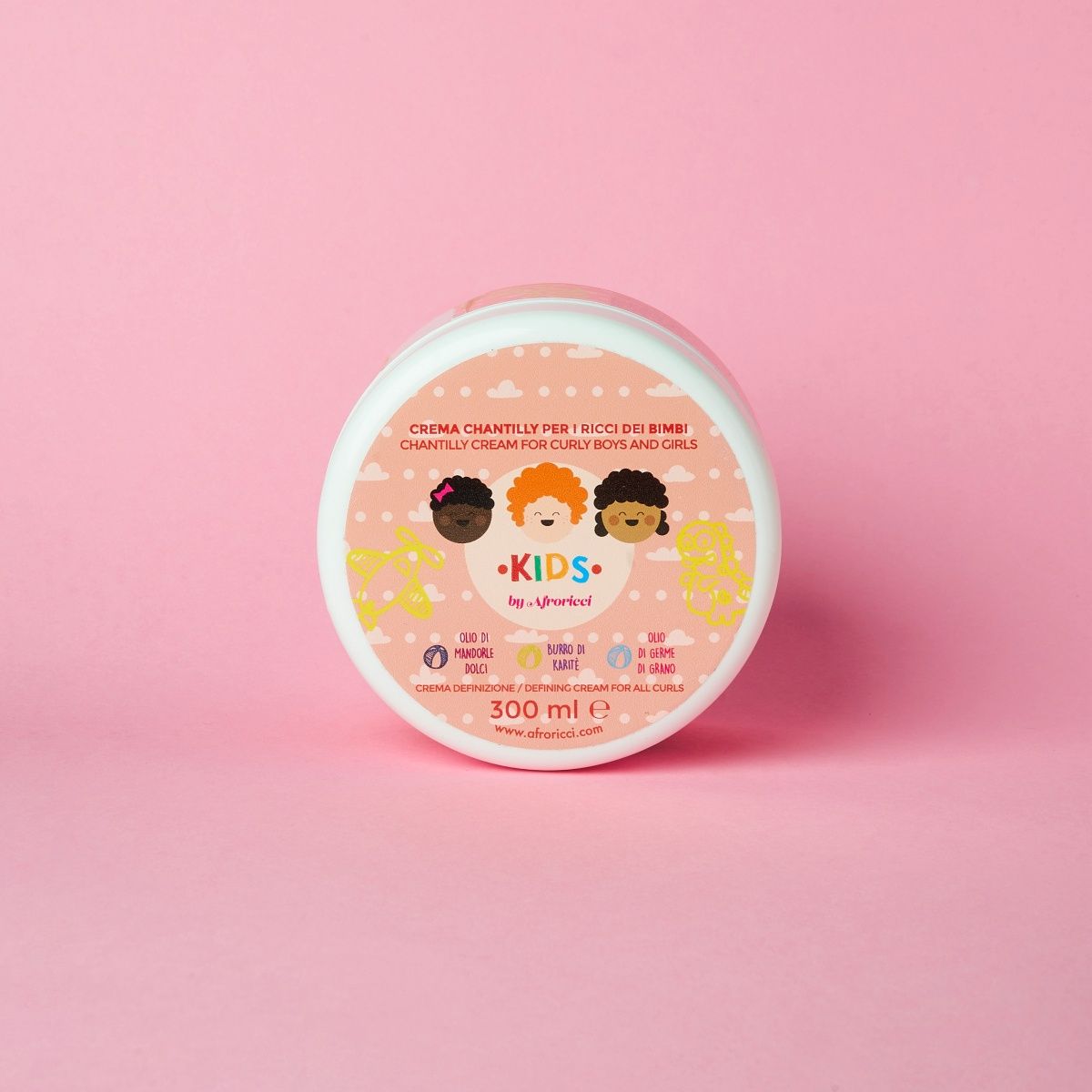 Barattolo rotondo con coperchio rosa. Scritta: Chantilly Crema Definizione Afro. Illustrazioni di volti di bambini. 300 ml.