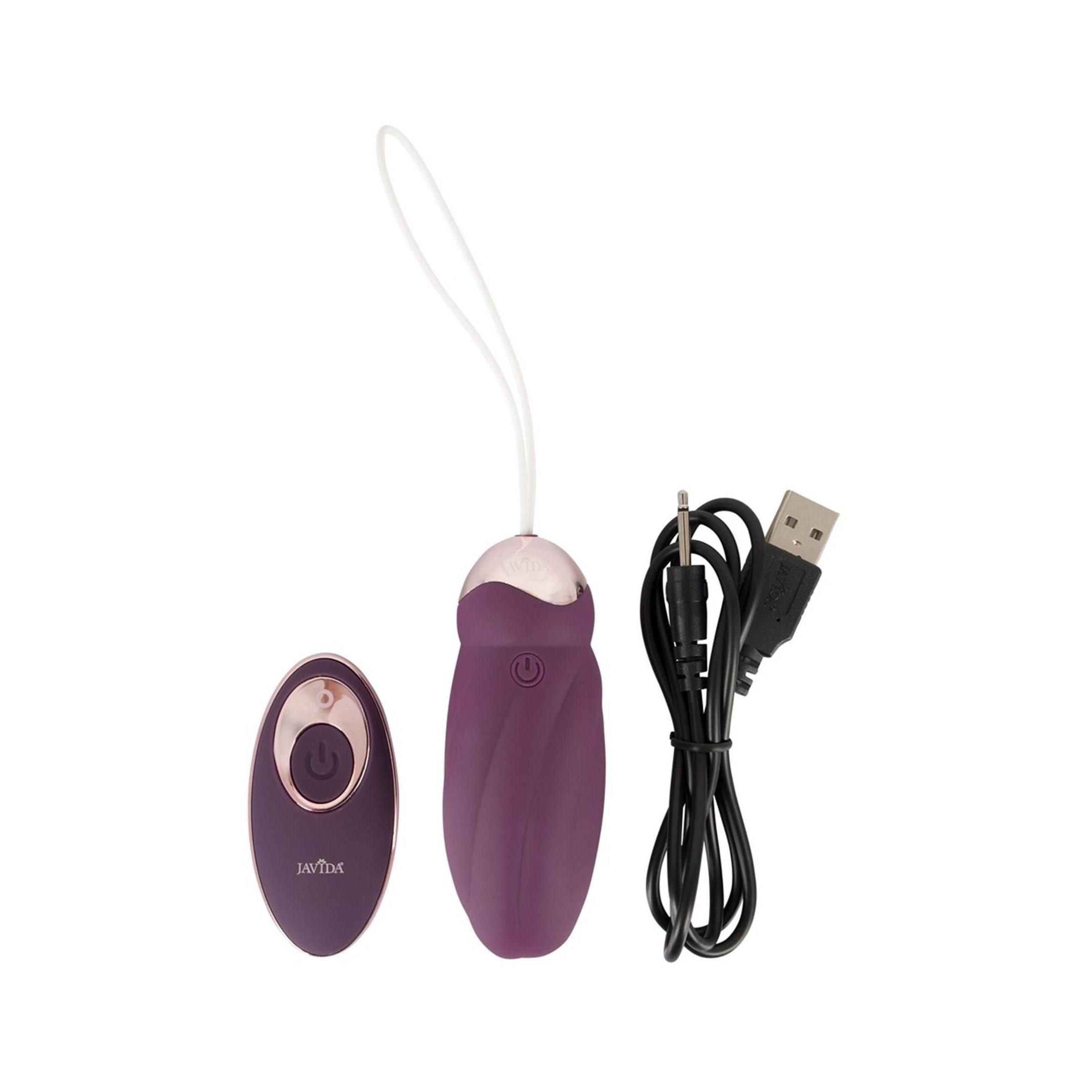 Massaggiatore viola, telecomando e cavo USB. Dettagli dorati. Sfondo bianco.