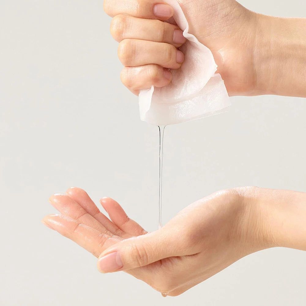 Mani che tengono un panno imbevuto, da cui cola del liquido. Il liquido viene raccolto nell'altra mano.