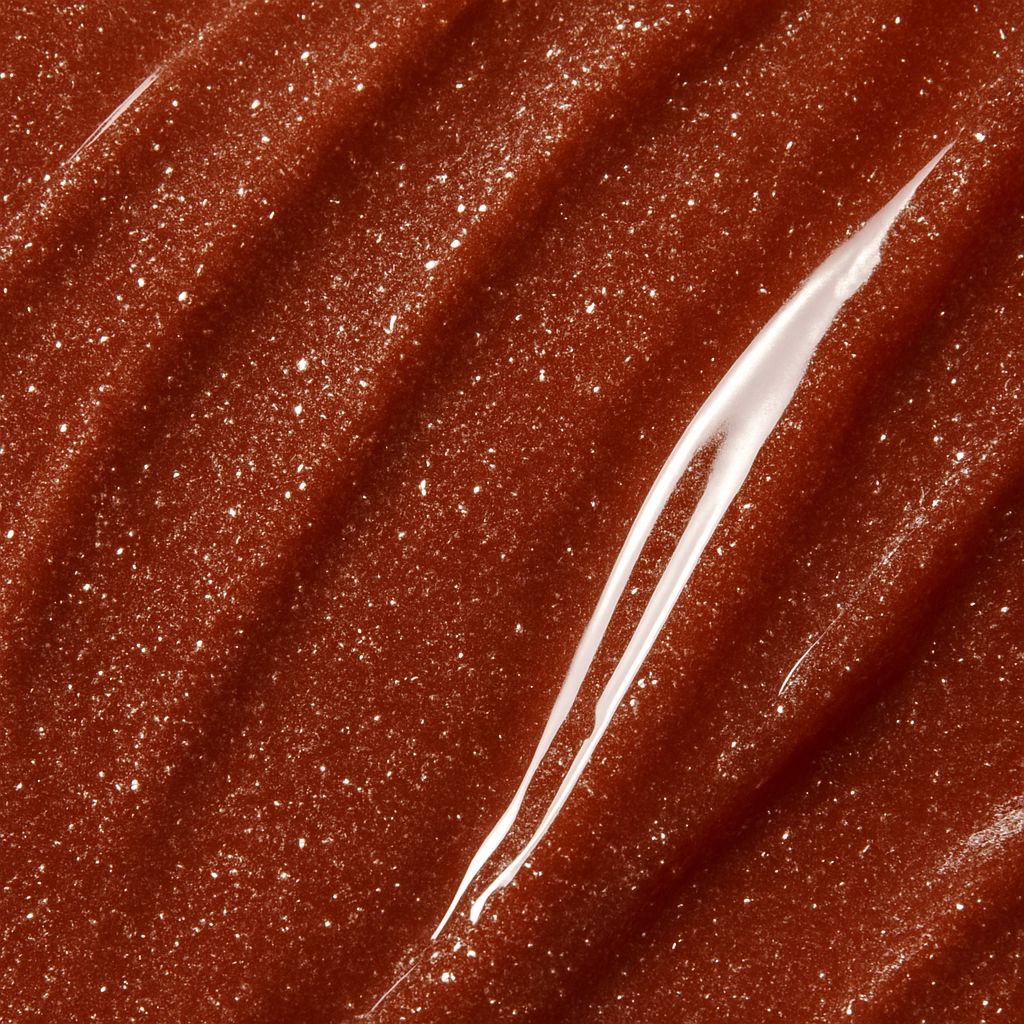 Primo piano di lucidalabbra marrone scintillante. Texture visibile e riflessi chiari.