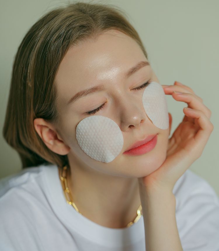 Donna con due patch oculari rotondi e bianchi sotto gli occhi.