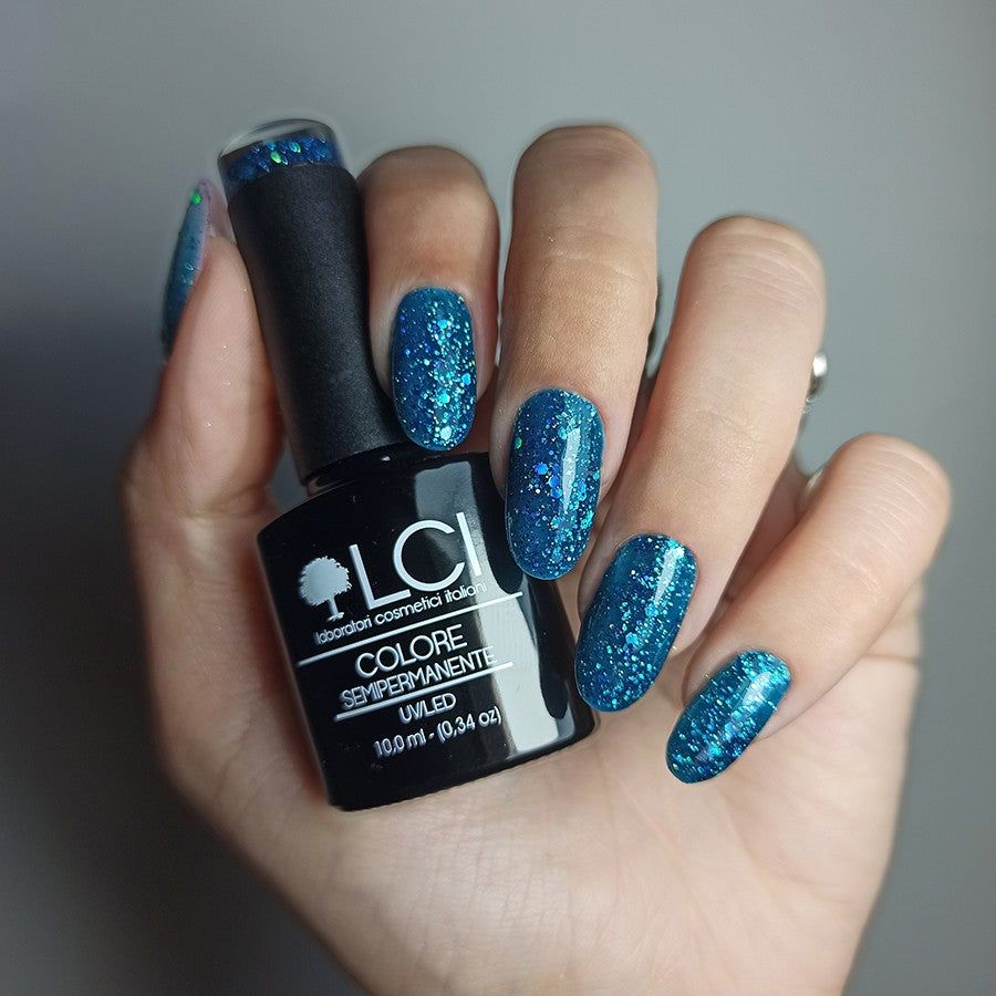 Mano con unghie smaltate e flacone di smalto. Scritta: LCI, Colore Semipermanente, UVLED 10,0 ml.