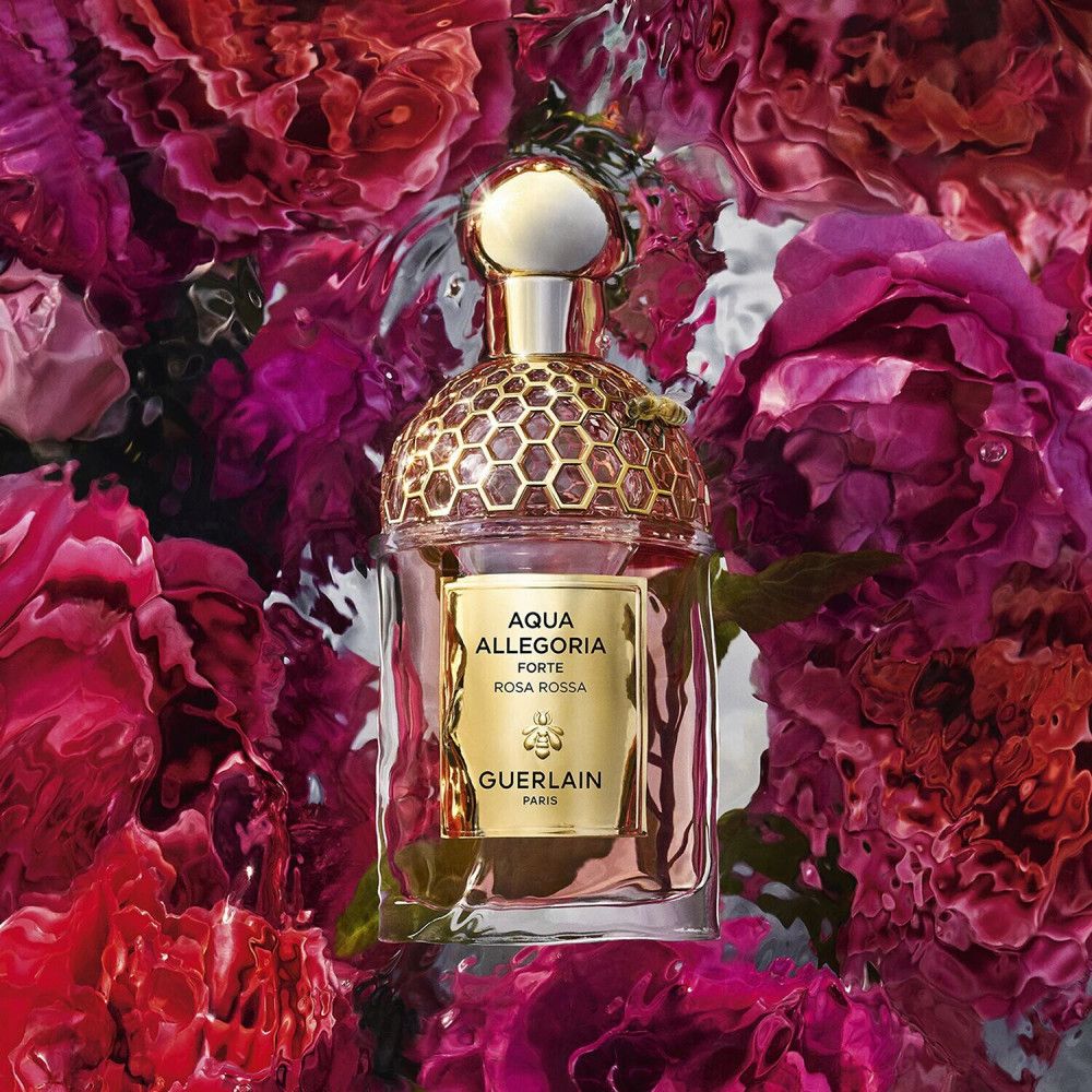 Flacone di profumo con tappo dorato. Etichetta: Aqua Allegoria Forte Rosa Rossa Guerlain Paris. Su petali di rosa in acqua.