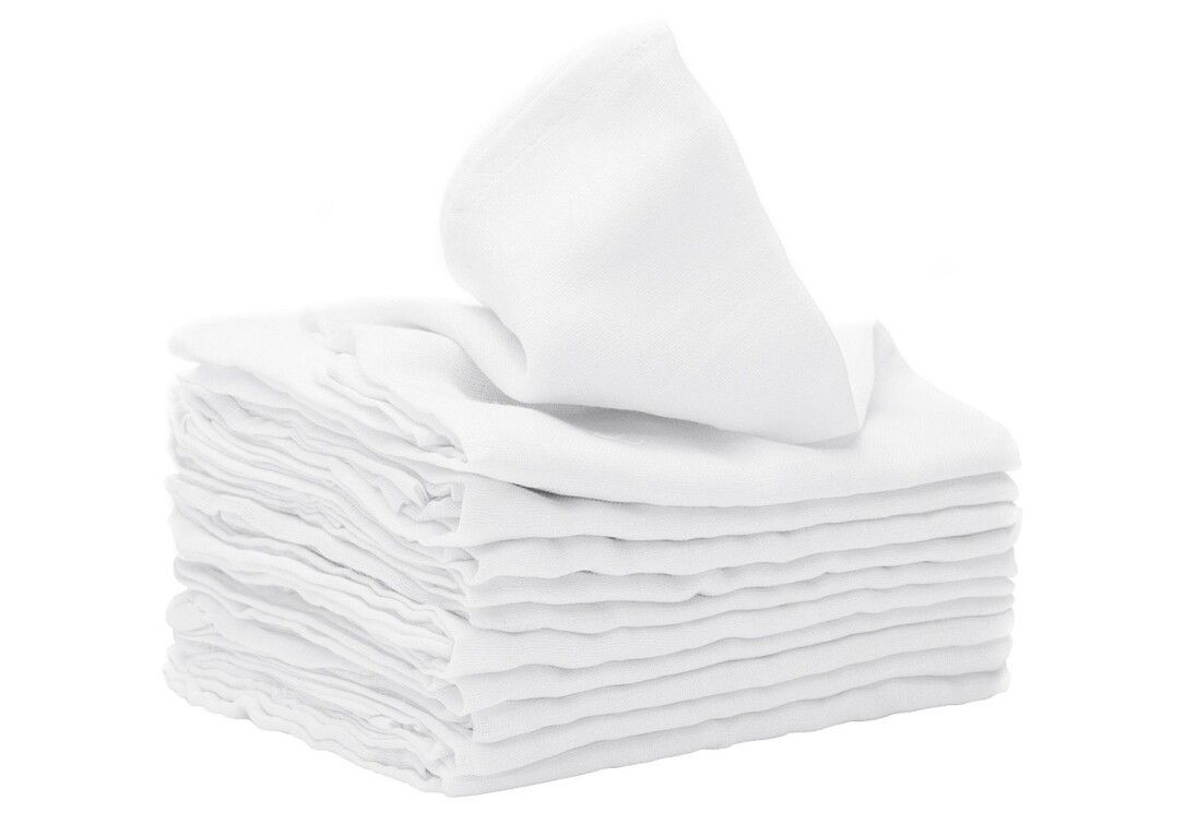 Pila di garze bianche, una parzialmente estratta. Forma quadrata, materiale morbido.