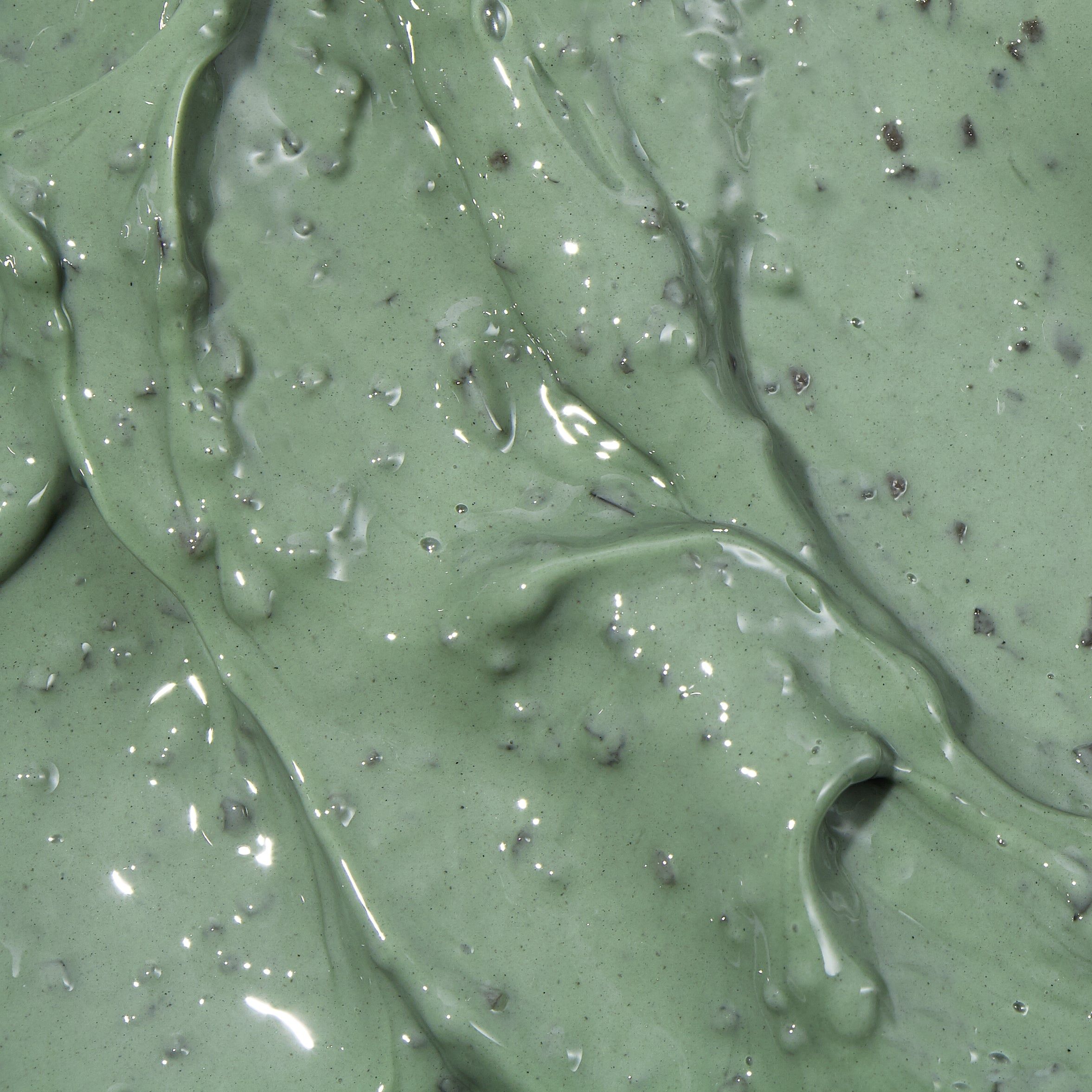Primo piano della maschera per il viso. Colore verde con piccole particelle scure. Superficie lucida.