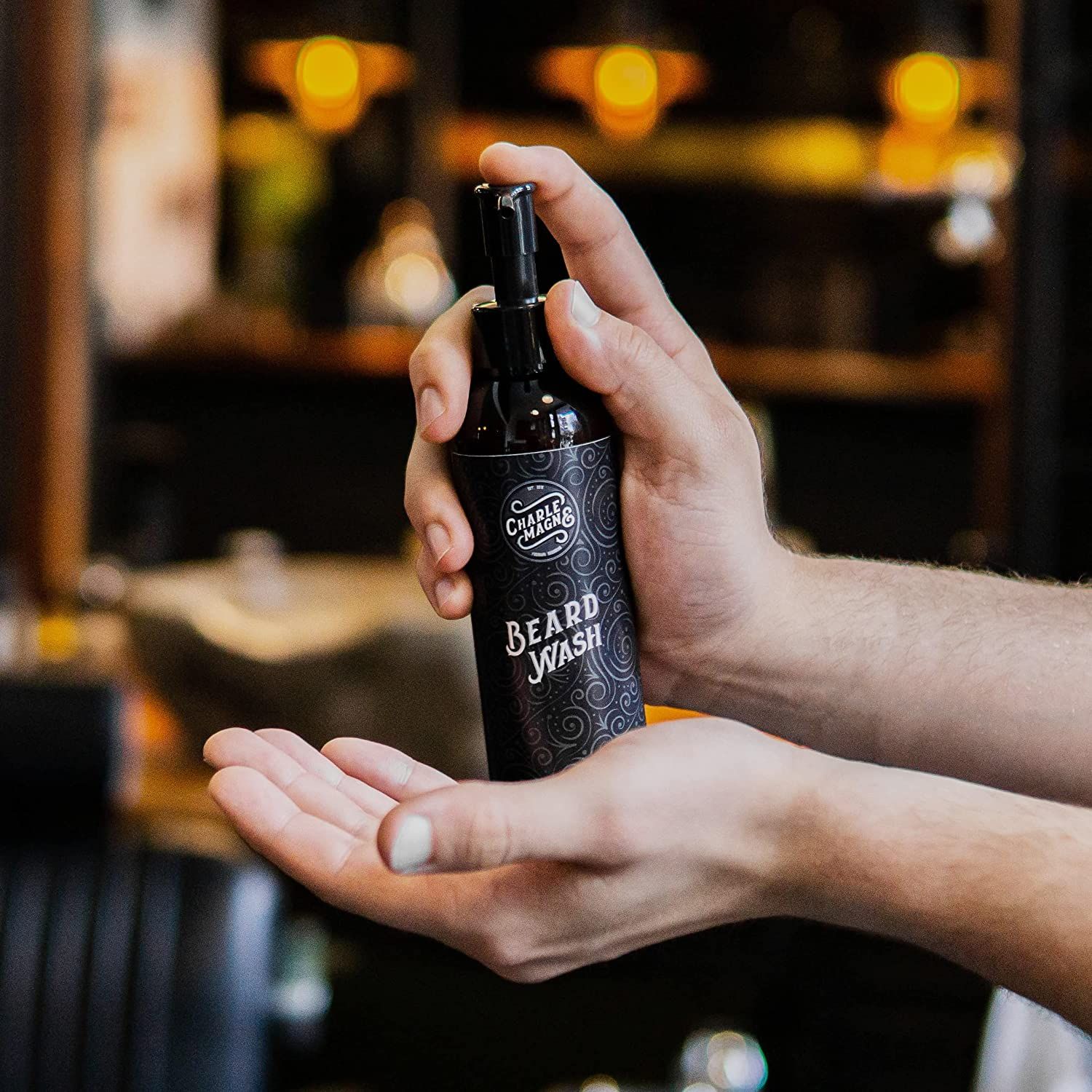 Flacone di lavaggio per barba con erogatore, tenuto tra le mani.