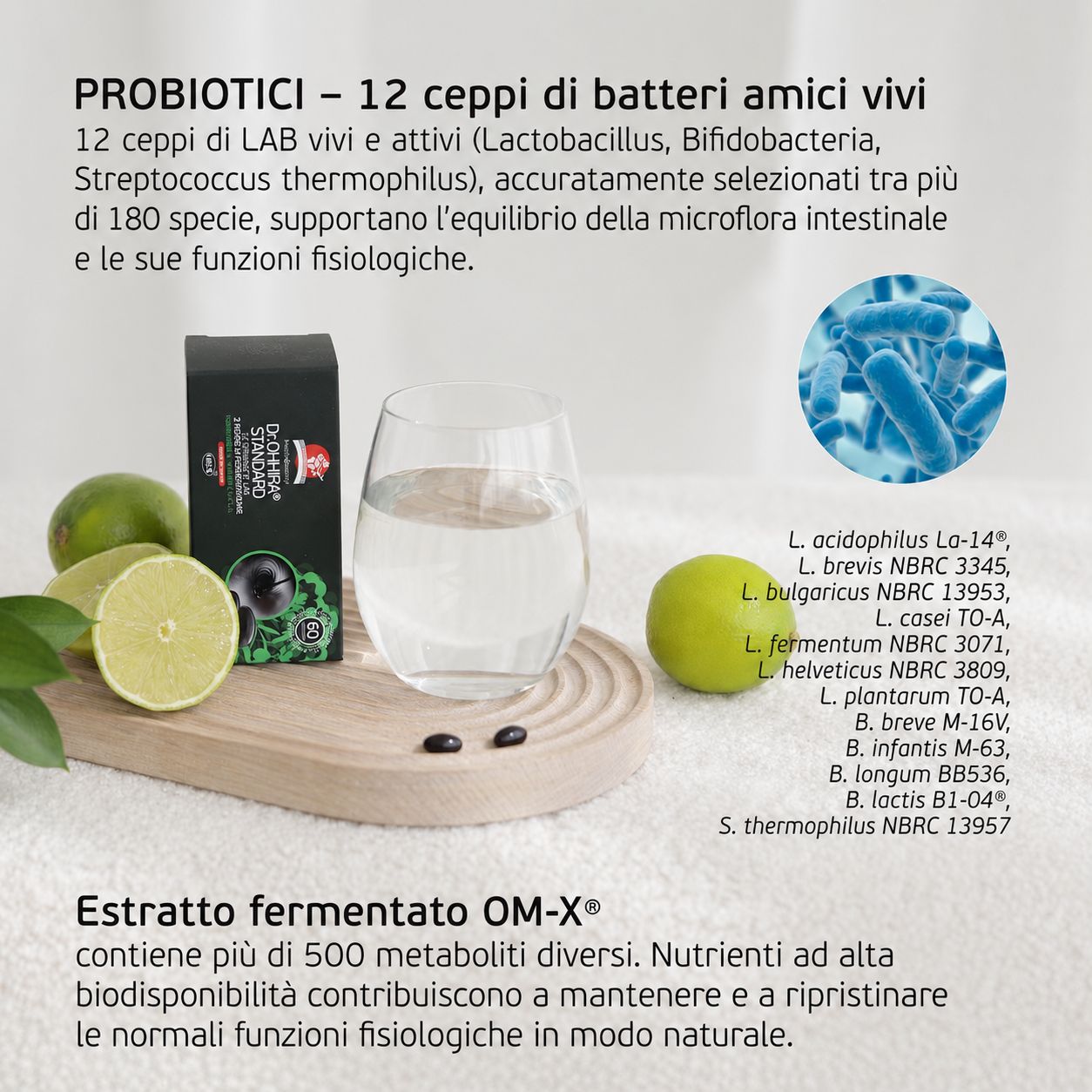 Confezione di probiotici accanto a un bicchiere d'acqua, spicchi di lime e capsule su un vassoio di legno.