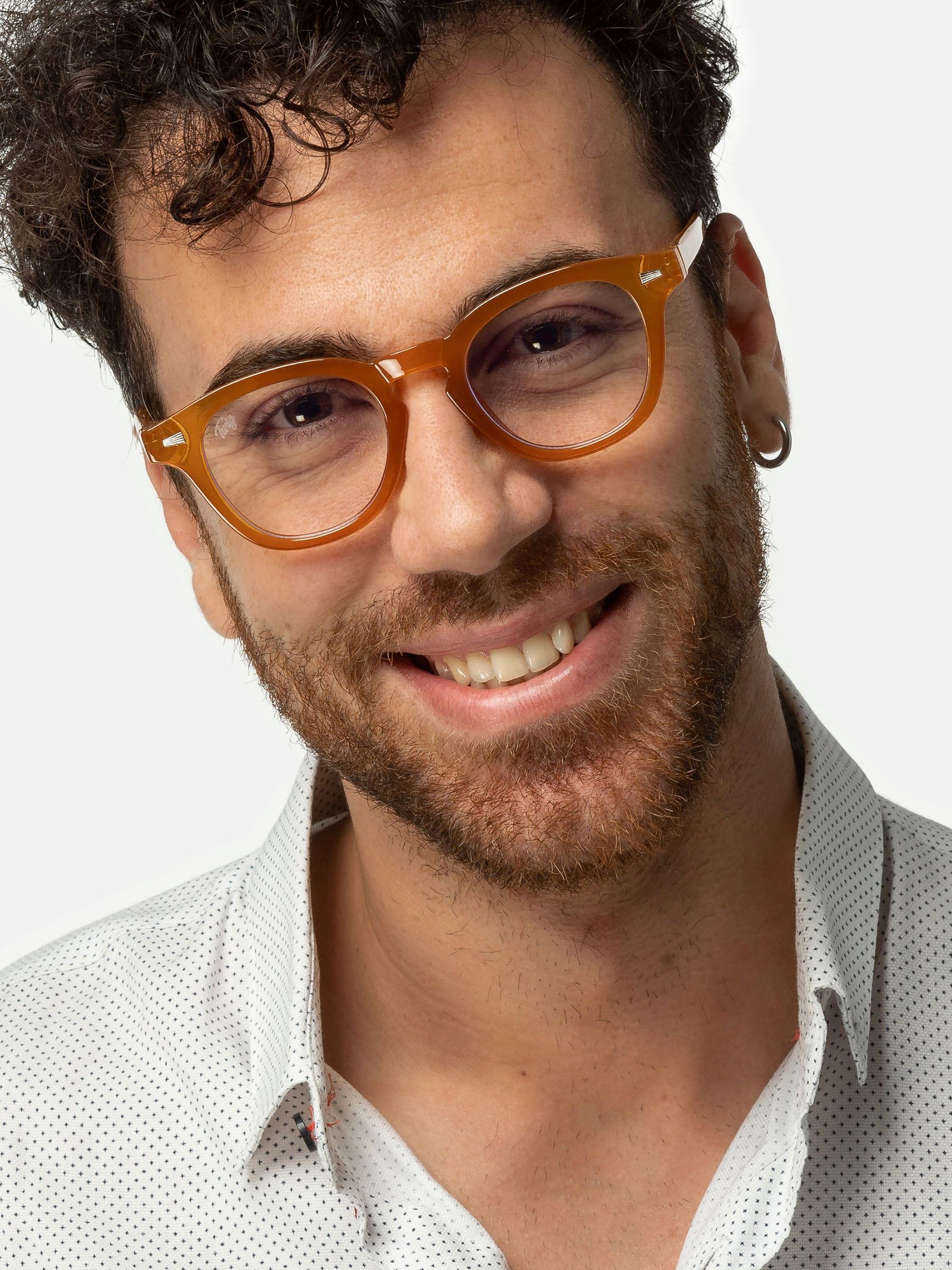 Uomo con occhiali. Occhiali rotondi, arancioni. L'uomo sorride.