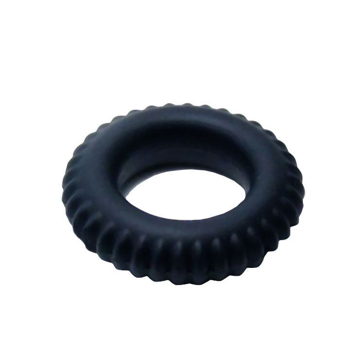 Anello fallico nero con superficie scanalata. Forma anulare con foro centrale.