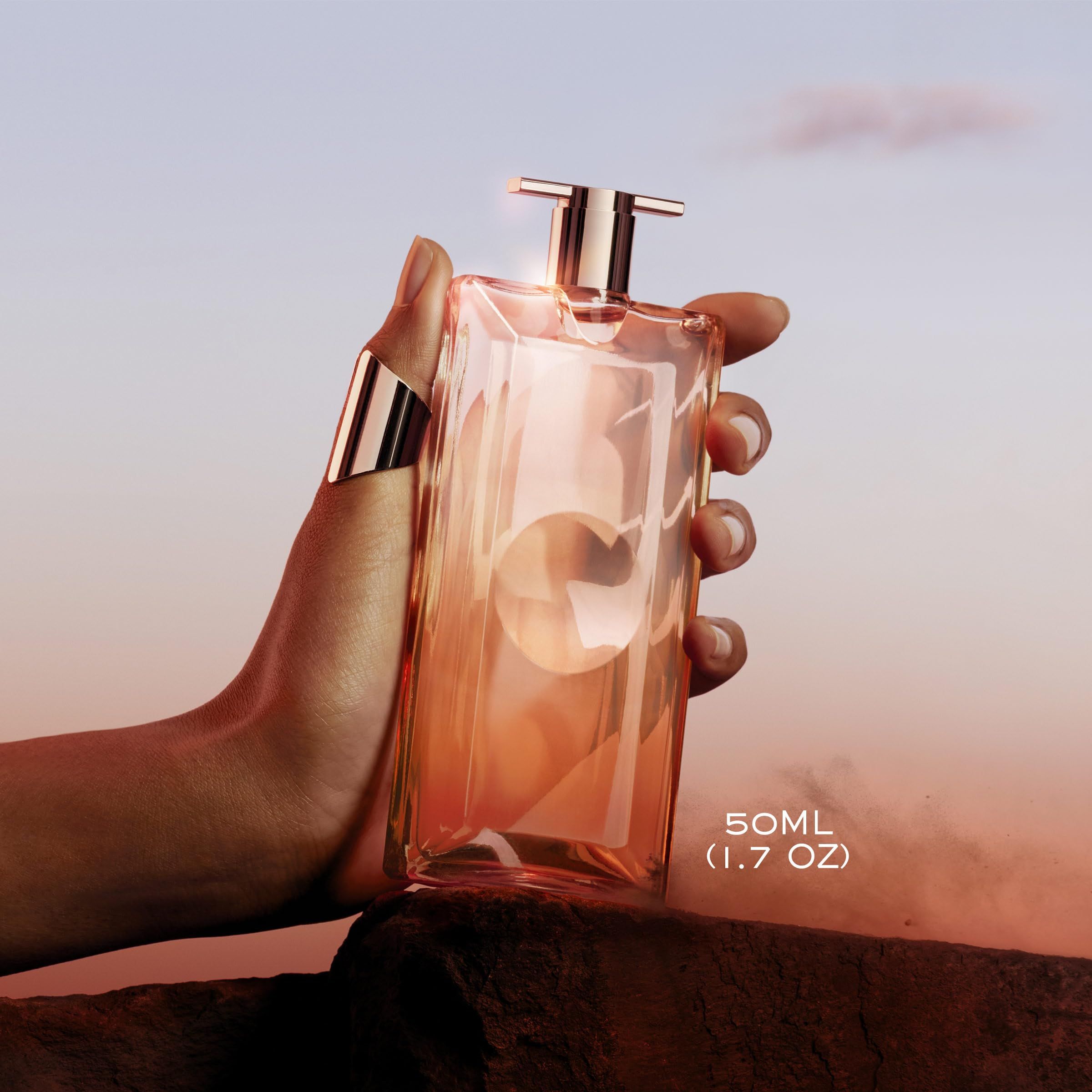 Flacone di profumo in una mano. 50ml. Nome del prodotto non visibile.