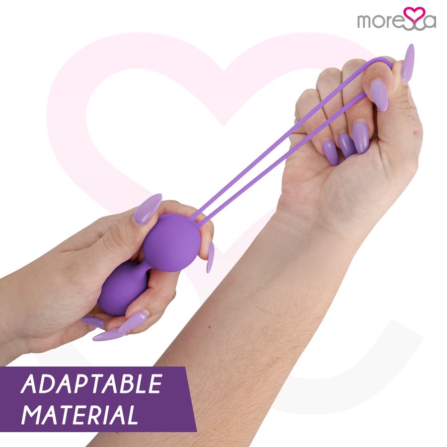 Mano che tiene due palle di Kegel lilla. Scritta: ADAPTABLE MATERIAL. Marchio: more❤️sa. Sfondo: cuore.