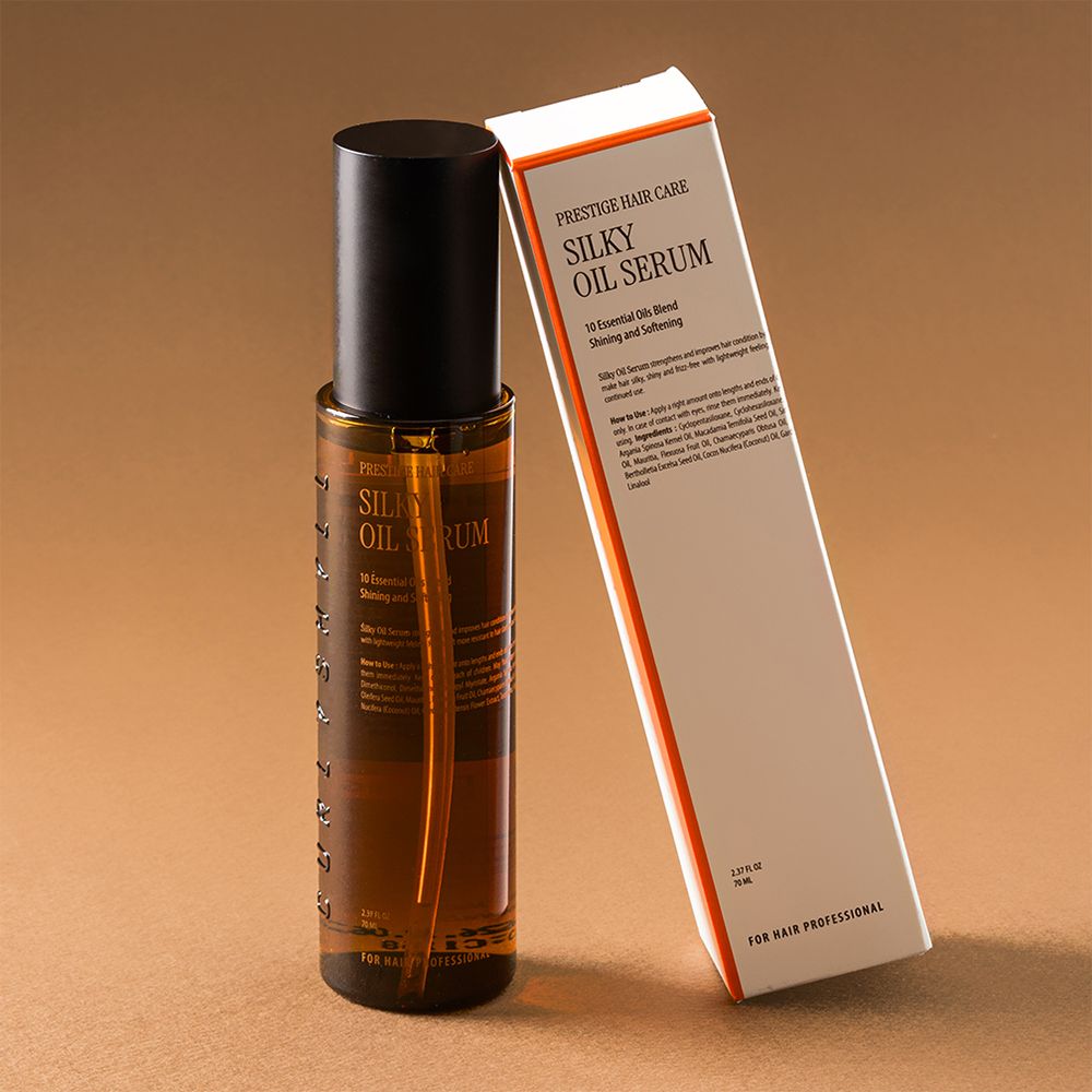Flacone di olio per capelli marrone con tappo nero e scatola. Scritta: Silky Oil Serum. Testo: 10 Essential Oils Blend. Per cura pro.