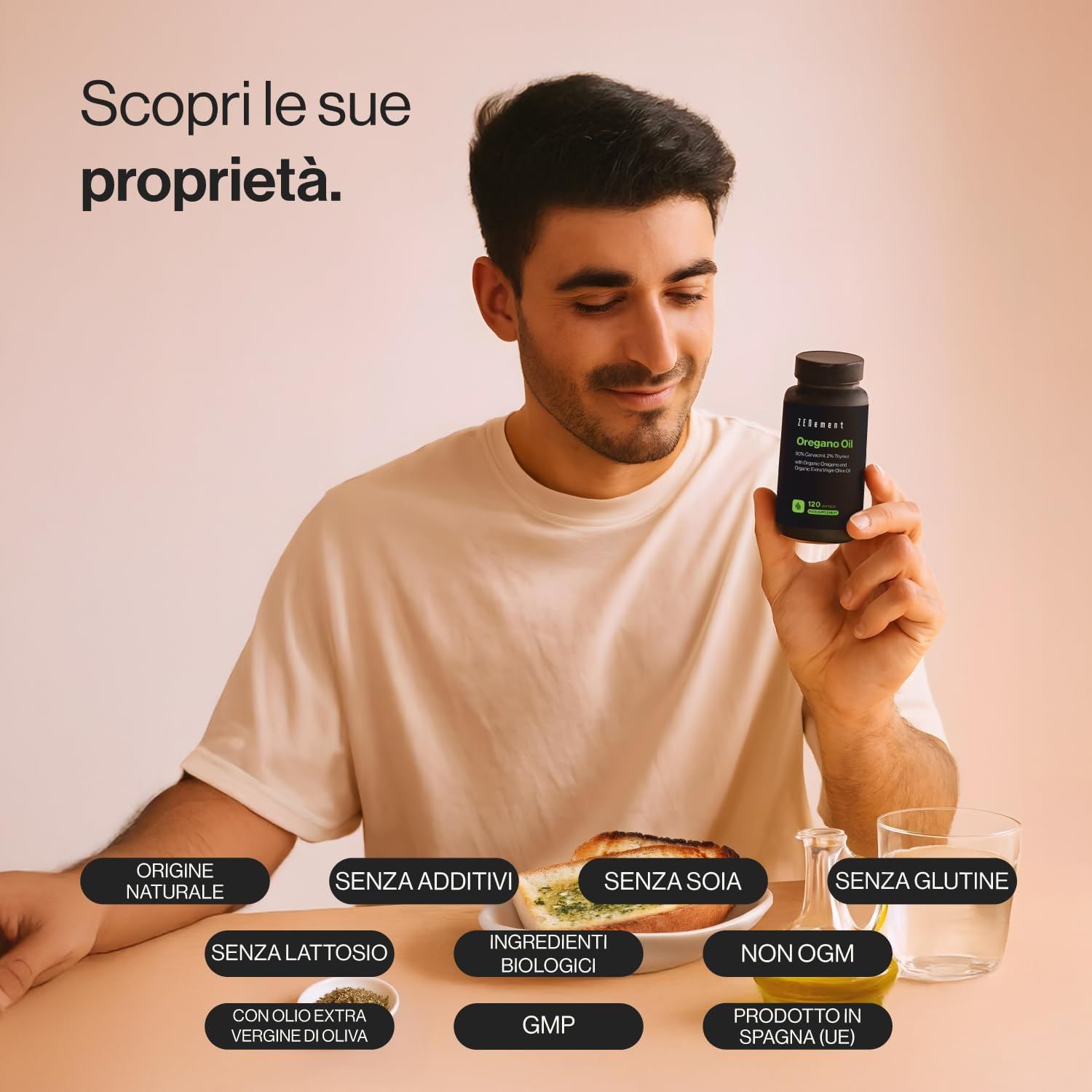Uomo che tiene una bottiglia di olio di origano Zenement. Scritta: Organic Oregano Oil. Sul tavolo: verdure, bicchiere d'acqua.