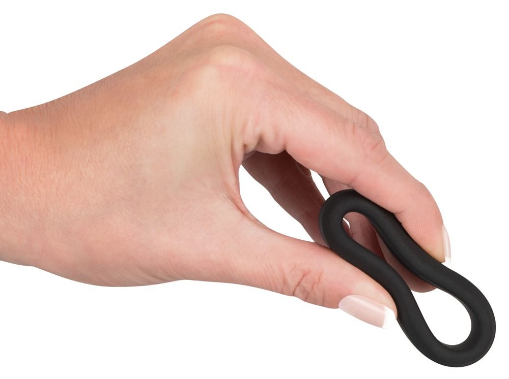 Mano che tiene un anello per pene nero flessibile in silicone.
