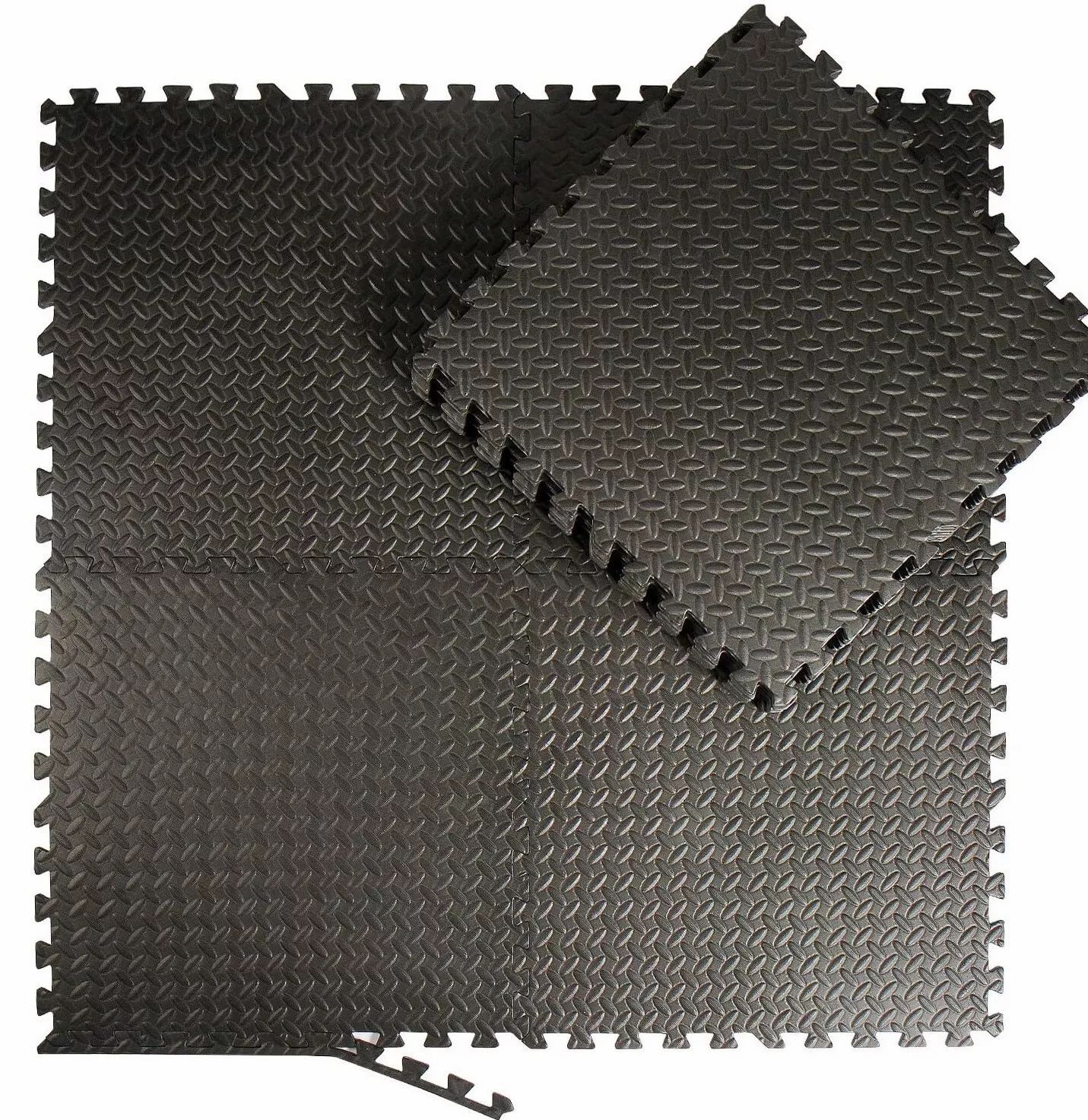 Tappeti puzzle neri collegati. Forma quadrata con superfici strutturate. Un tappeto sciolto accanto.