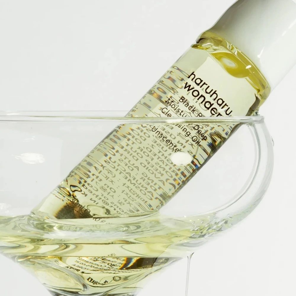 Flacone di olio detergente in un bicchiere. Scritta: haruharu wonder Black Rice Moisture Cleansing Oil.