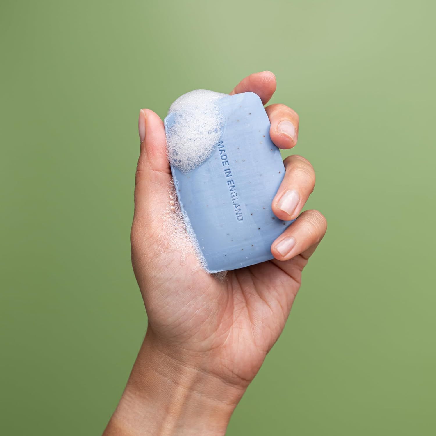 Sapone blu con schiuma in una mano. Scritta: Made in England.