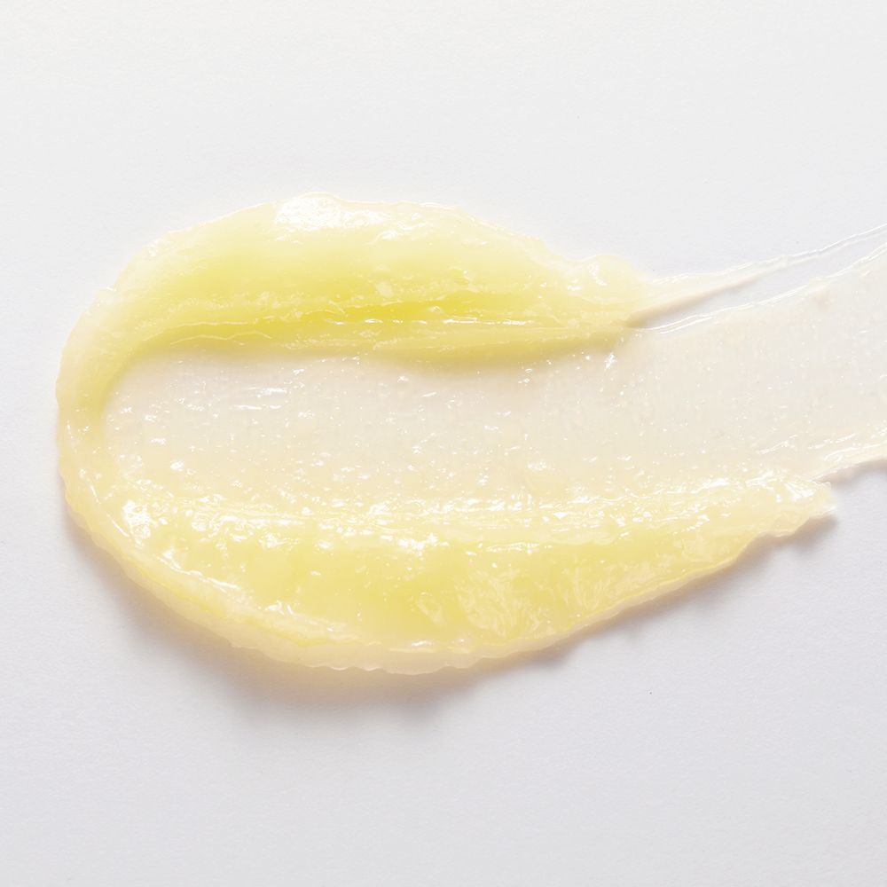 Striscia di balsamo giallo su sfondo bianco. Nessun packaging visibile.